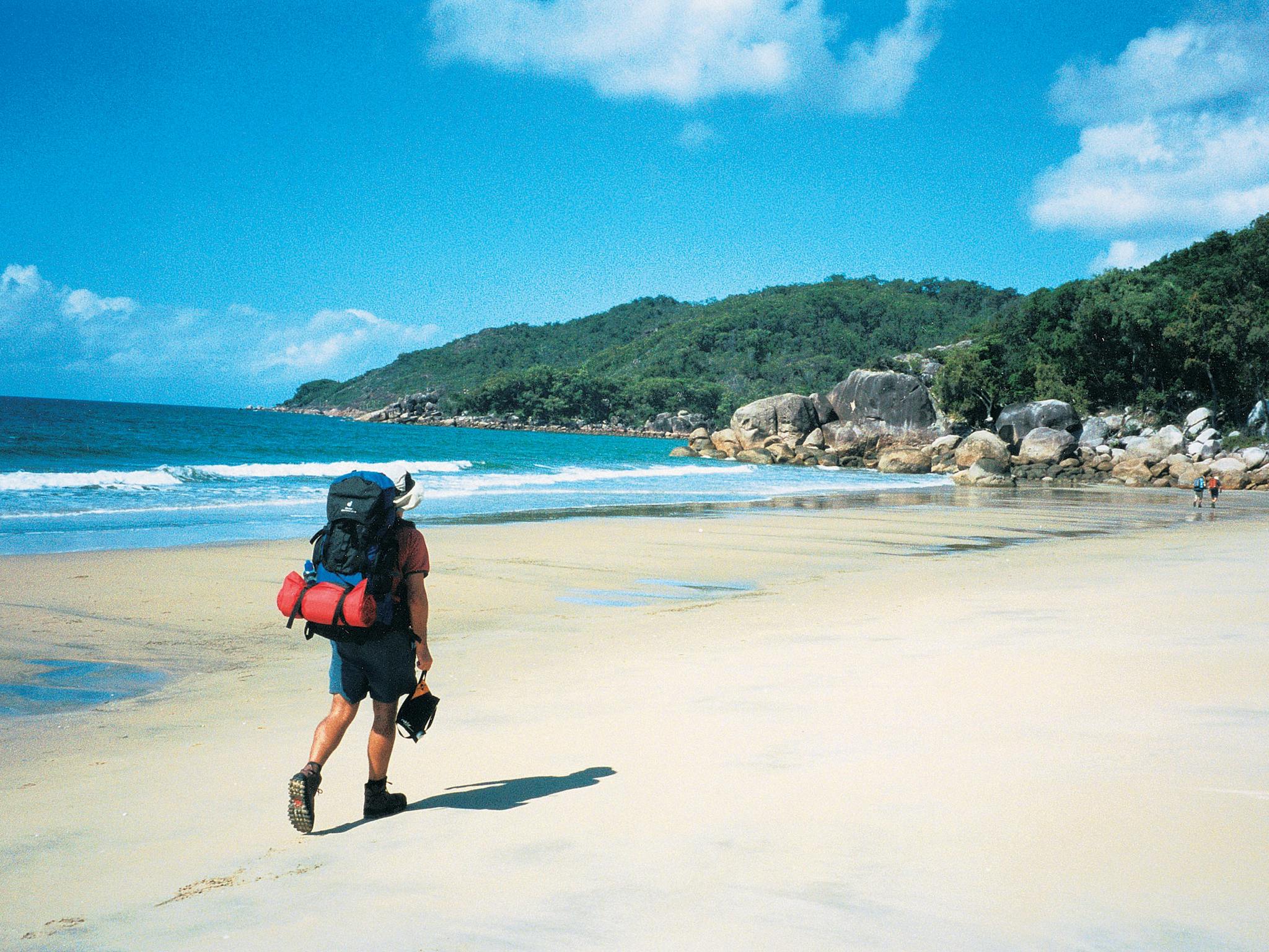 Walkers with overnight packs on beach in Ramsay Bay.