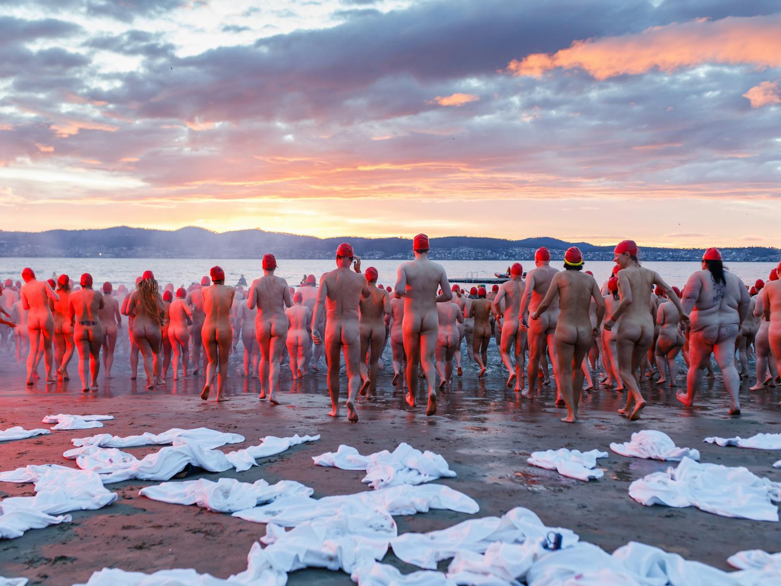 Thousands of people run into the River Derwent at sunrise for Dark Mofo's annual Nude Solstice Swim