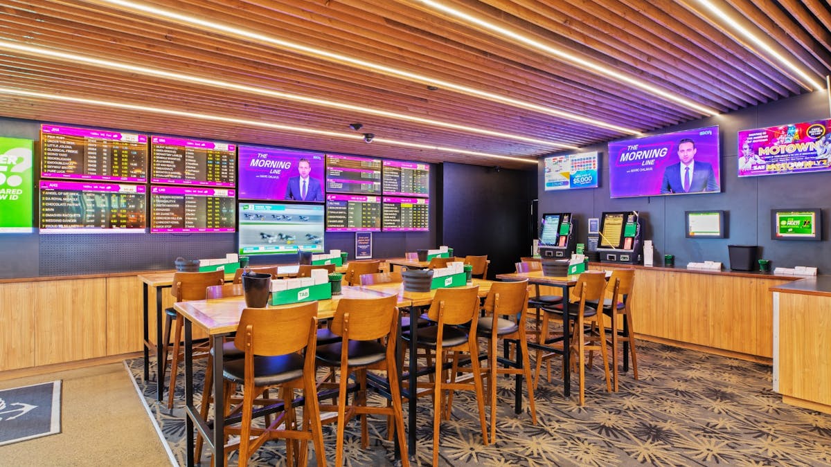 TAB area at The Pub Airlie Beach Hotel with multiple screens showing live racing and sports