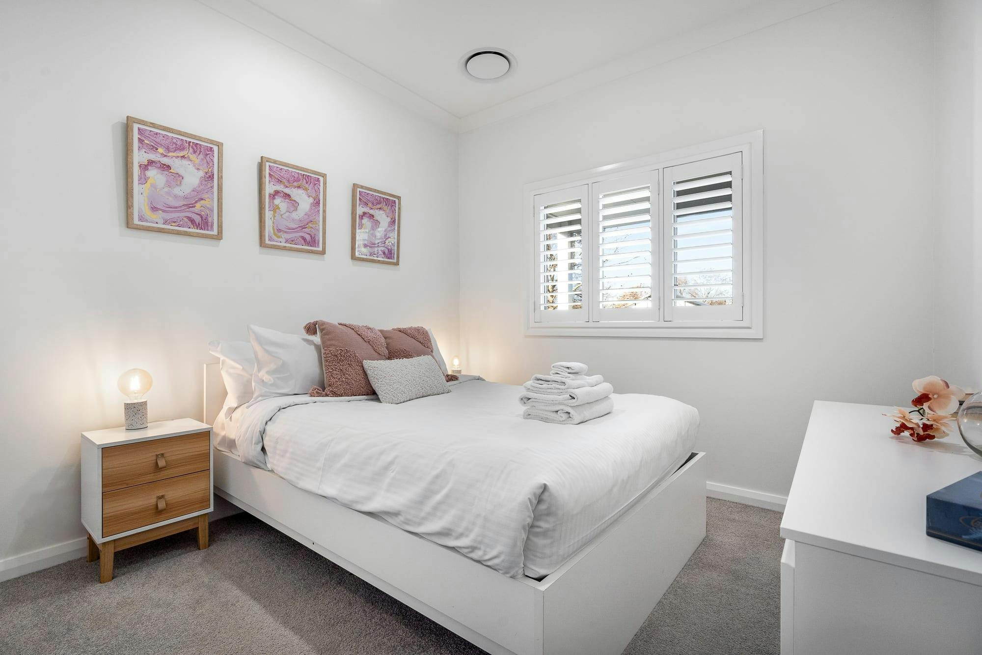 サイドテーブルと窓のある寝室