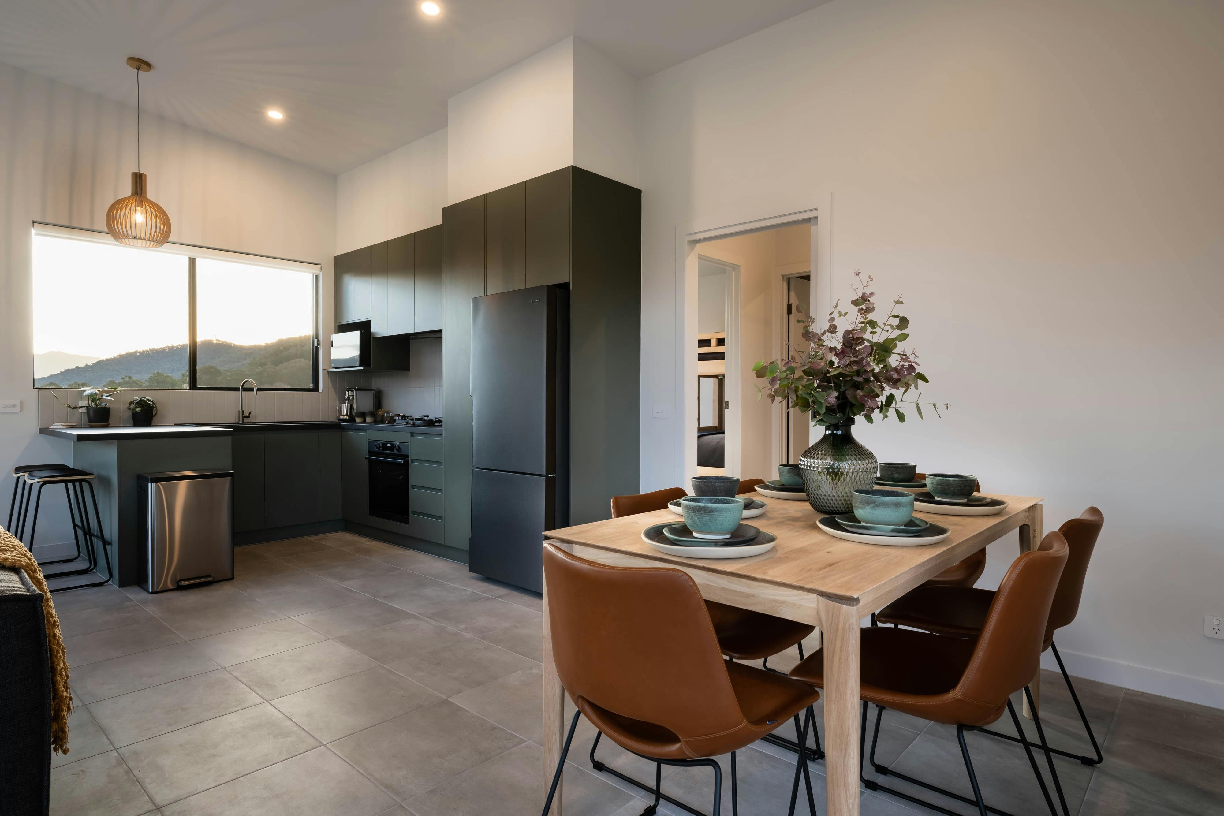 Slate green kitchen with beautiful wood table set with custom pottery