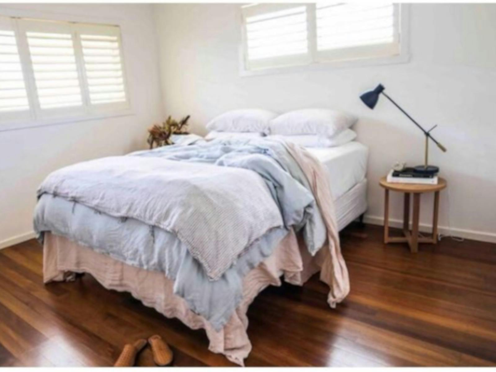 bedroom photo a beautiful comfy bed in a light filled room with timber floors