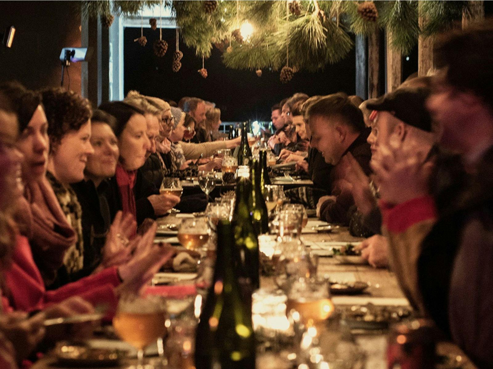 Long table dinner outside against a winter night sky