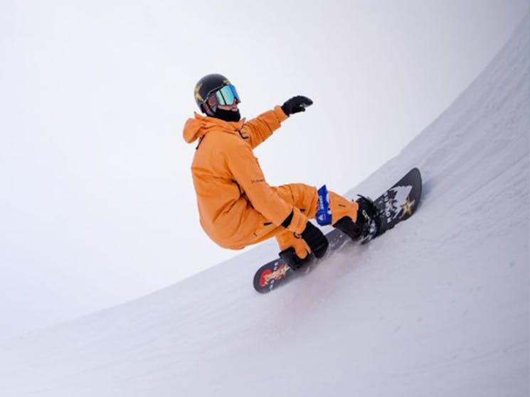 snowboarder riding half pipe