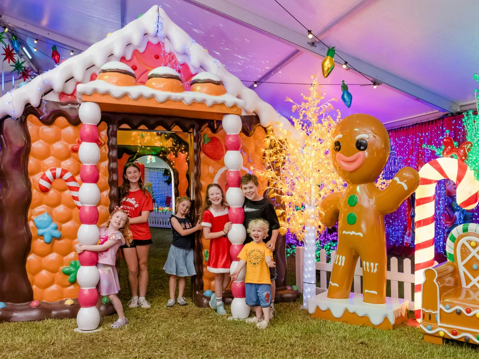 Children stood outside a giant, colourful gingerbread cottage