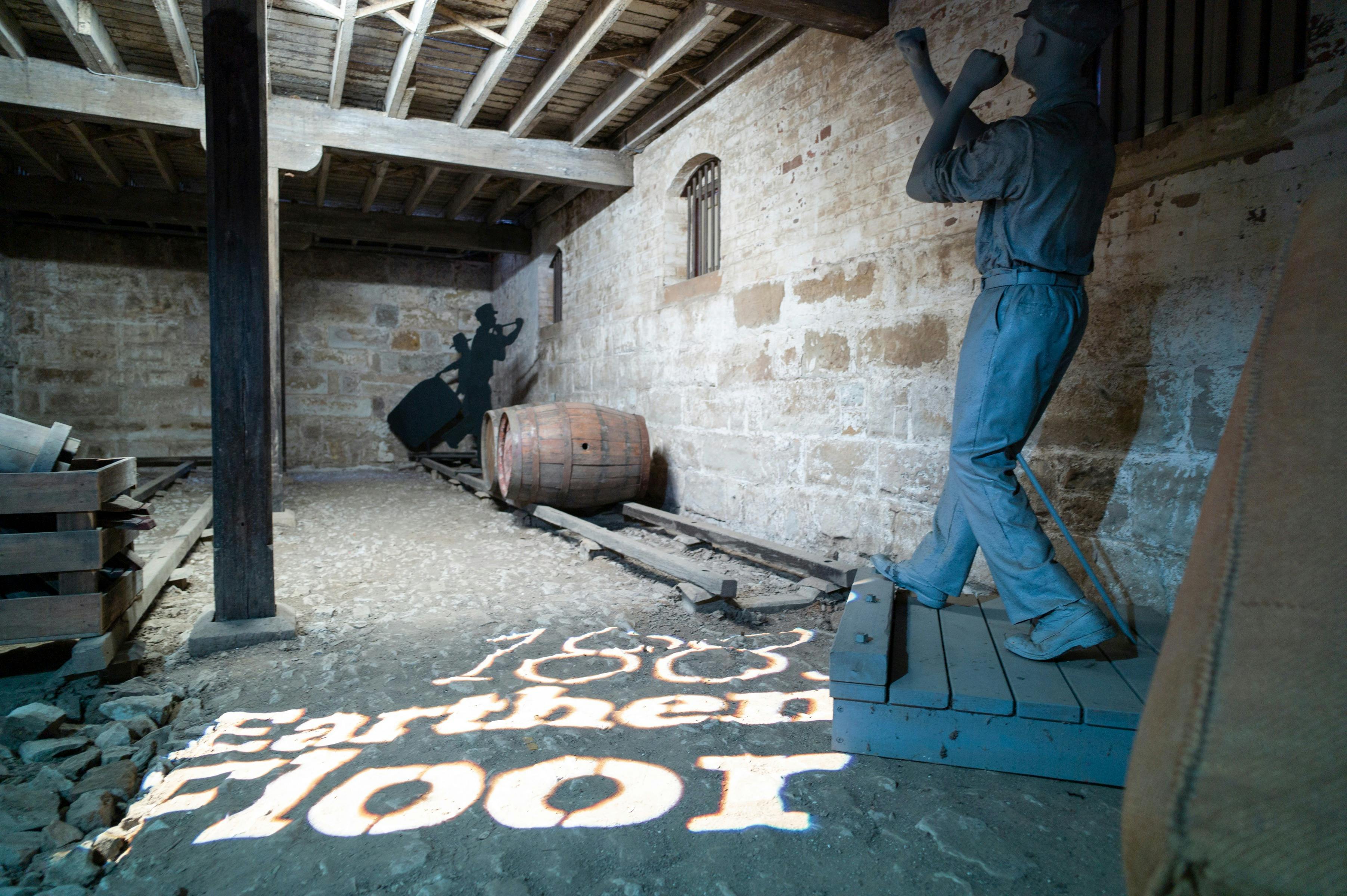 Photo inside Bond Store Museum depicting workers loading barrels in the basement.