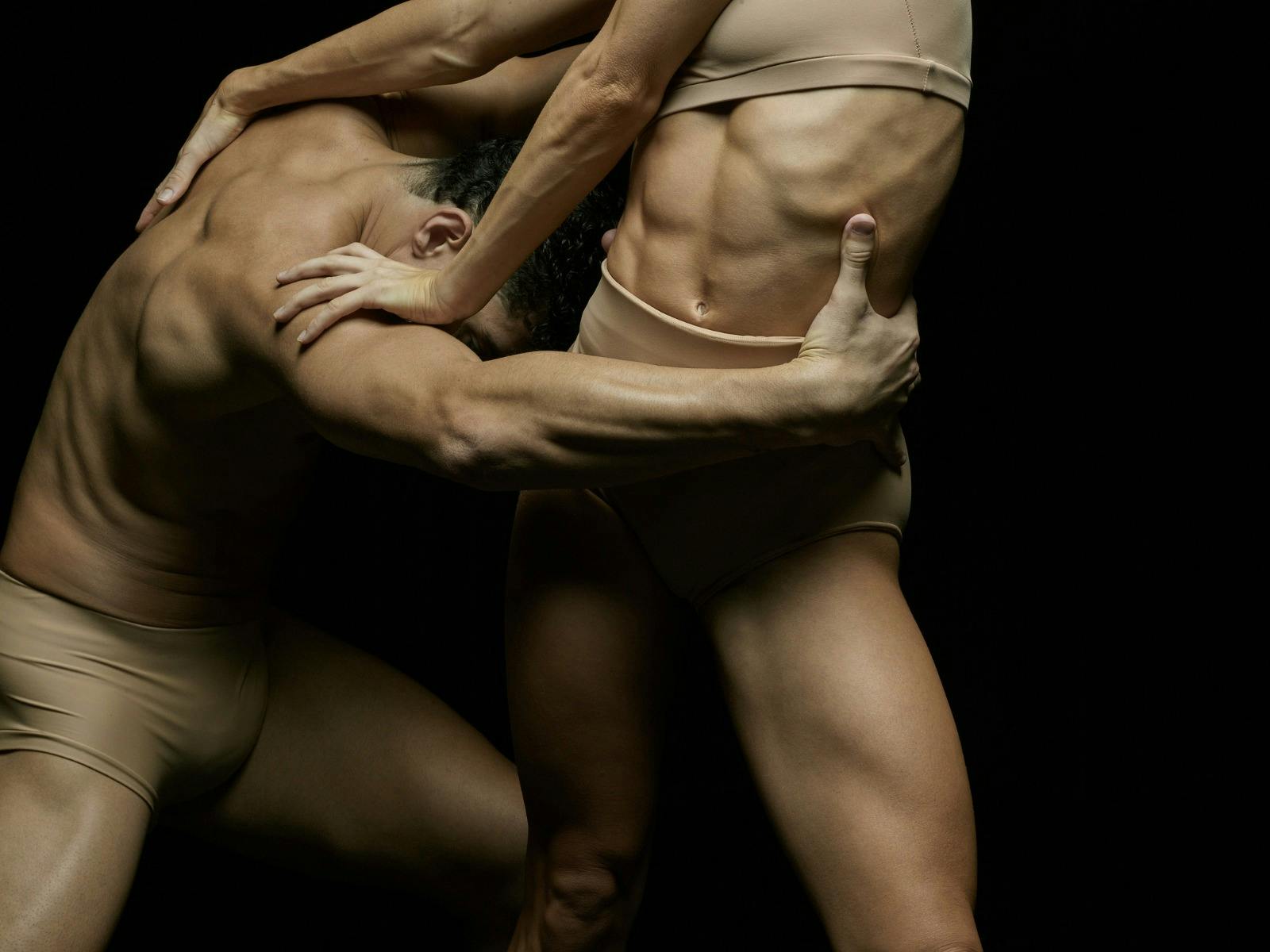 Two dancers show strength through their body holding each other