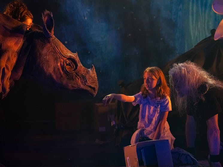 Image of young girl surrounded by animal puppets.