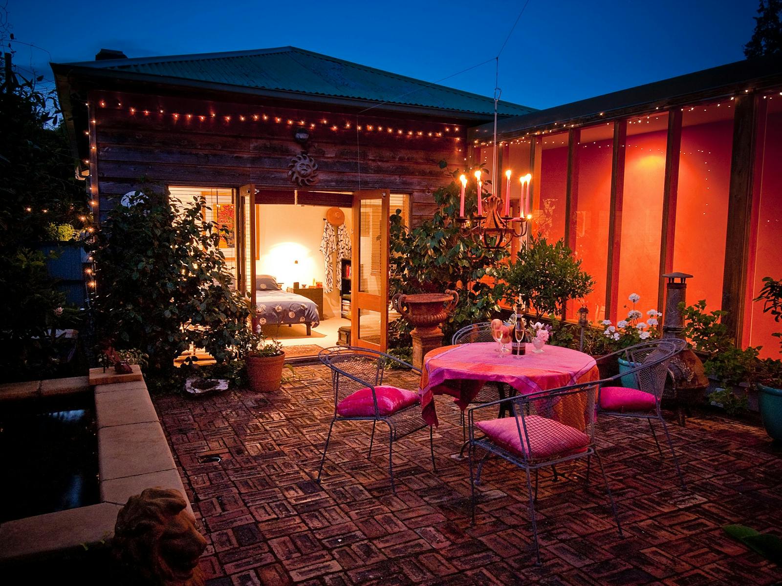 Private courtyard with warm glow of the chandelier and tinkling  sounds of the fountain