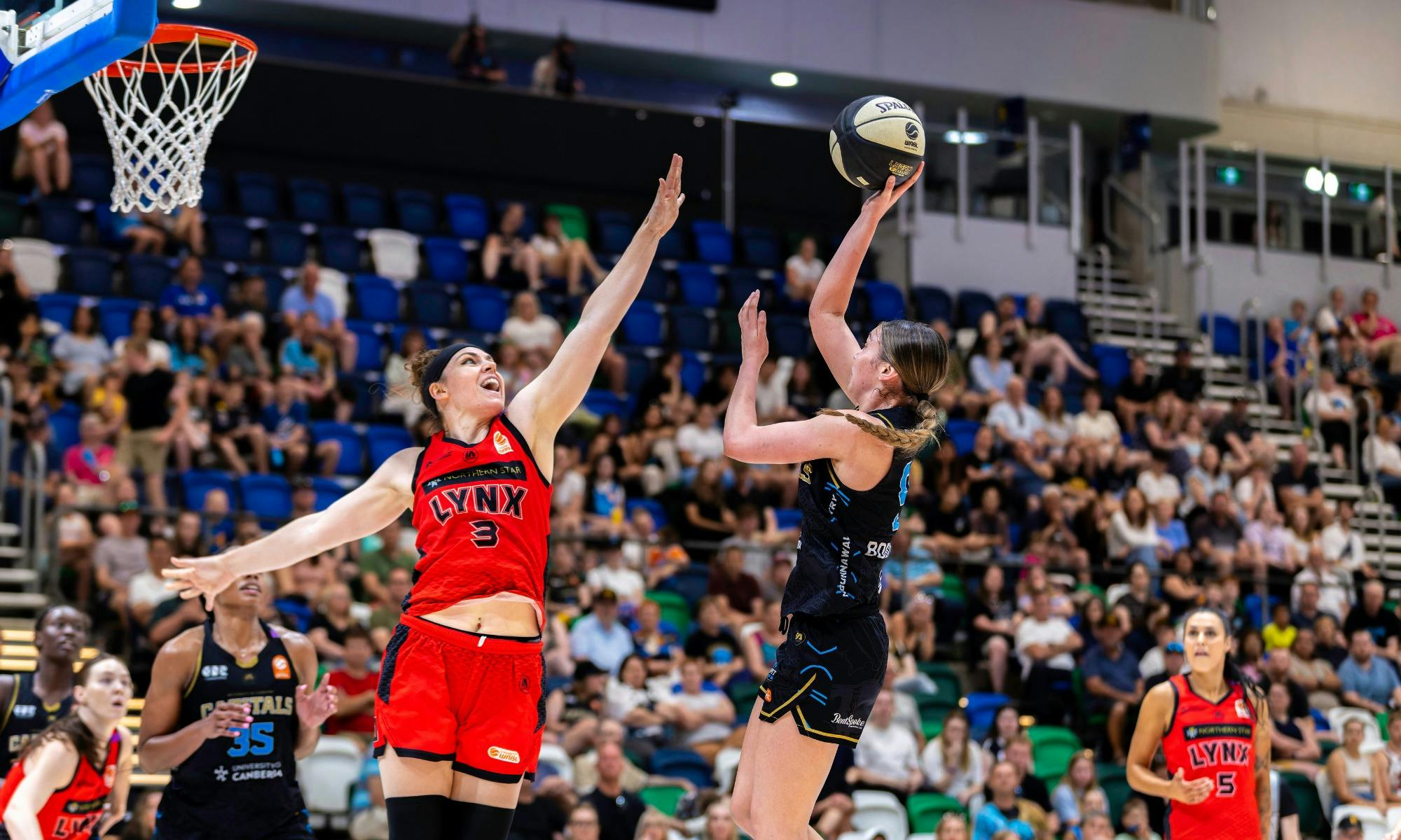 UC Capitals player shooting the basketball while a defender closes in.