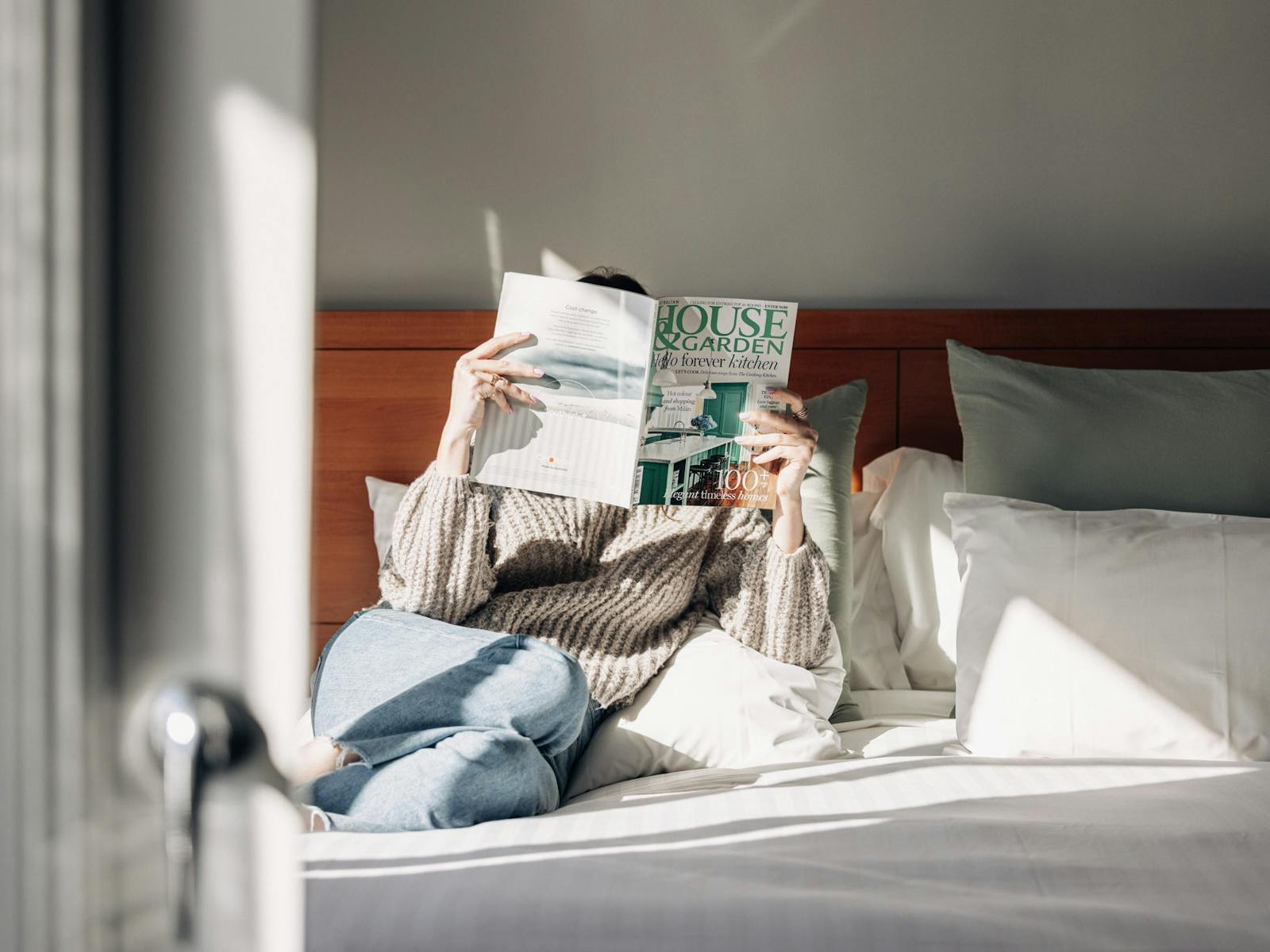 Lifestyle image of women on hotel bed reading magazine