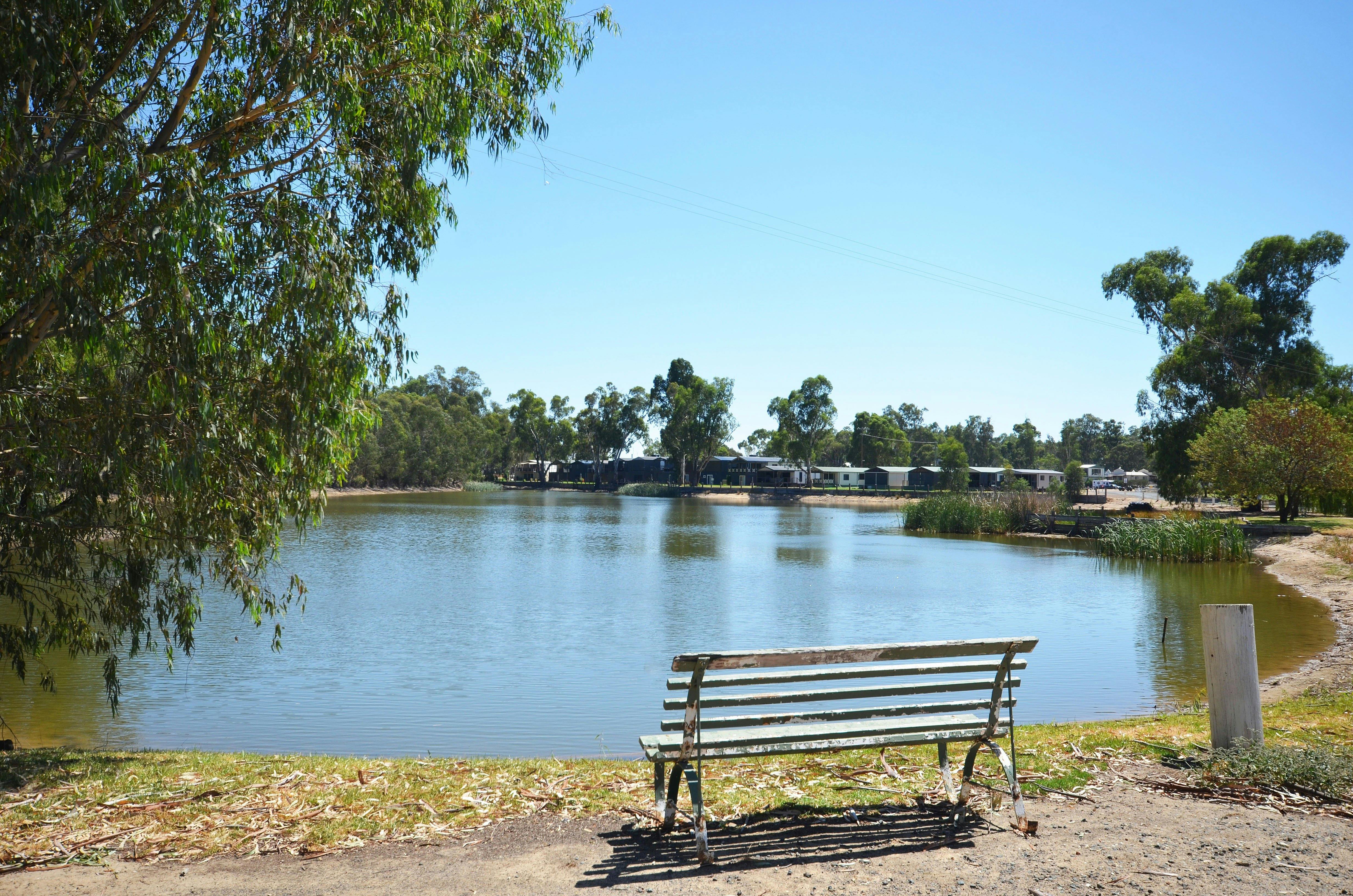 Picnic bench on lake with cabins in background
