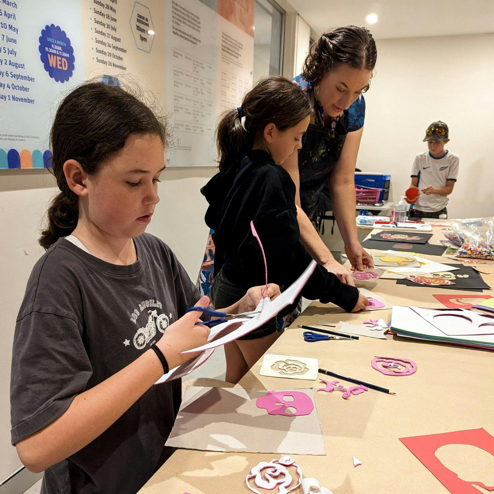 a child uses scissors to cut out paper during an art workshop