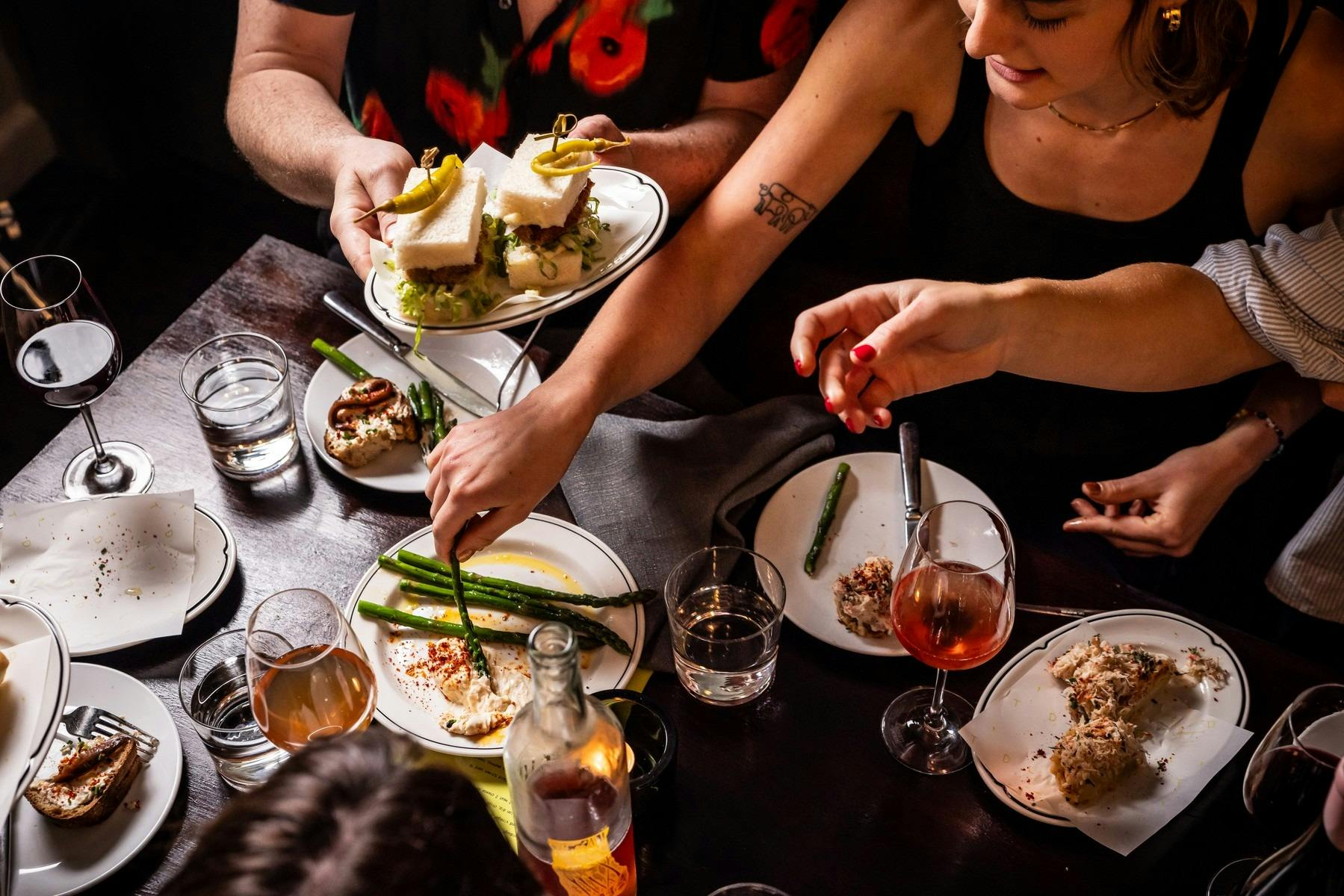A table of share food with people digging in