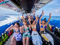 Guests experiencing a fast boat ride with hands in the air out of enjoyment