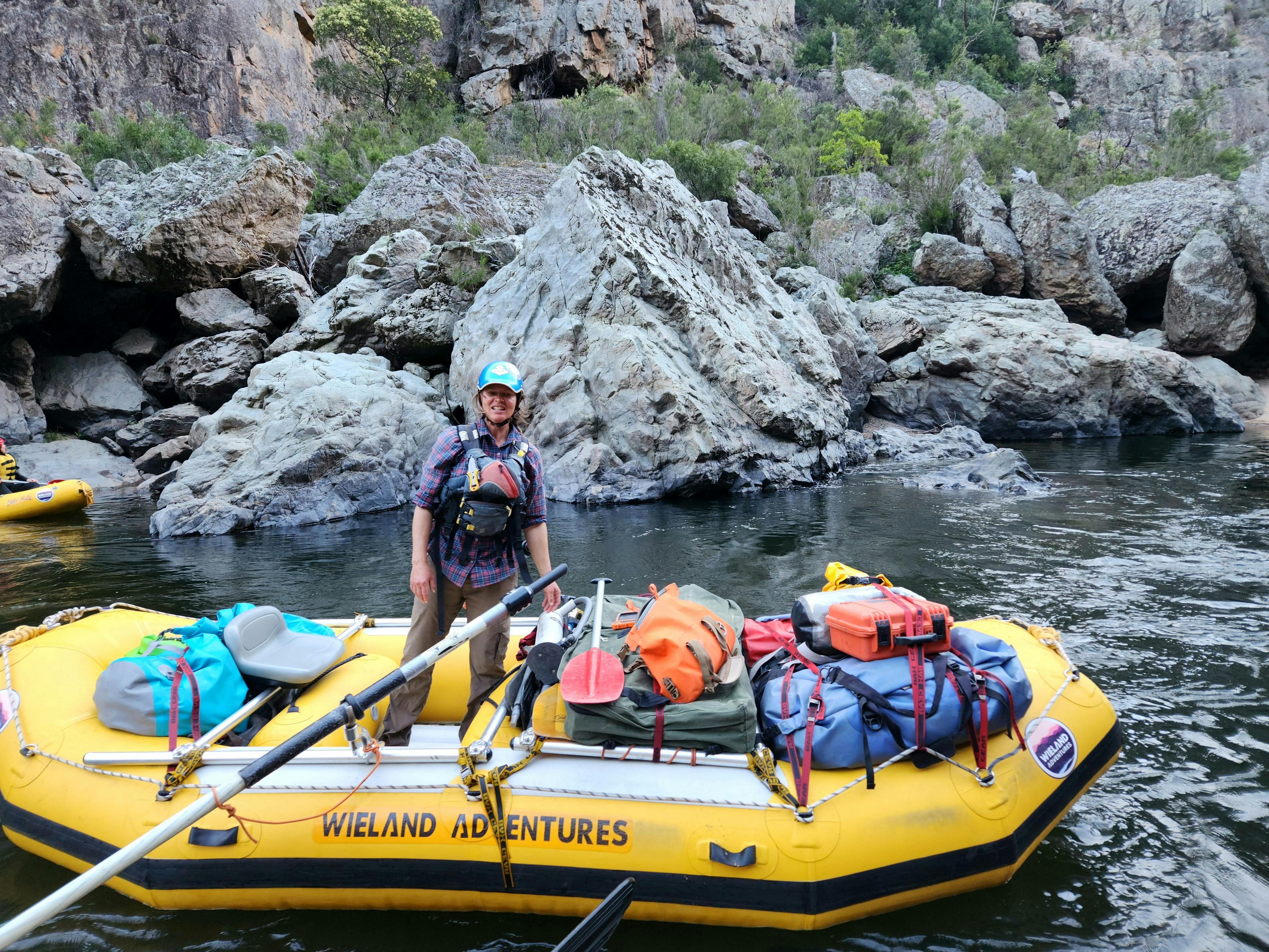 A Female raft guide on the Snowy River in her gear boat during an expedition.