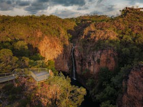 Aerial view of couple standing on a lookout gazing at Tolmer Falls in Litchfield National Park