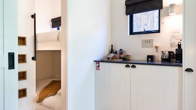Kitchenette to the right and an open door to the left showing a cosy bunk bed room