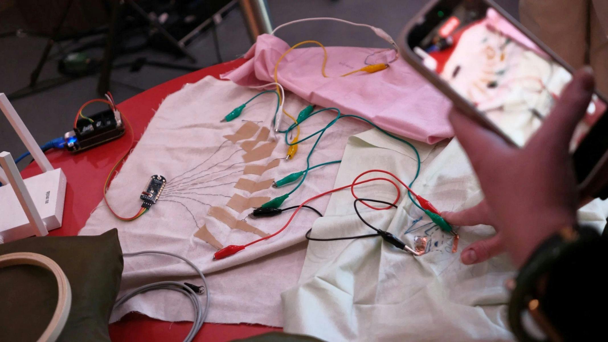 A photo of some textile fabric swatches with electrical nodes and cords attached