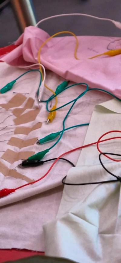 A photo of some textile fabric swatches with electrical nodes and cords attached