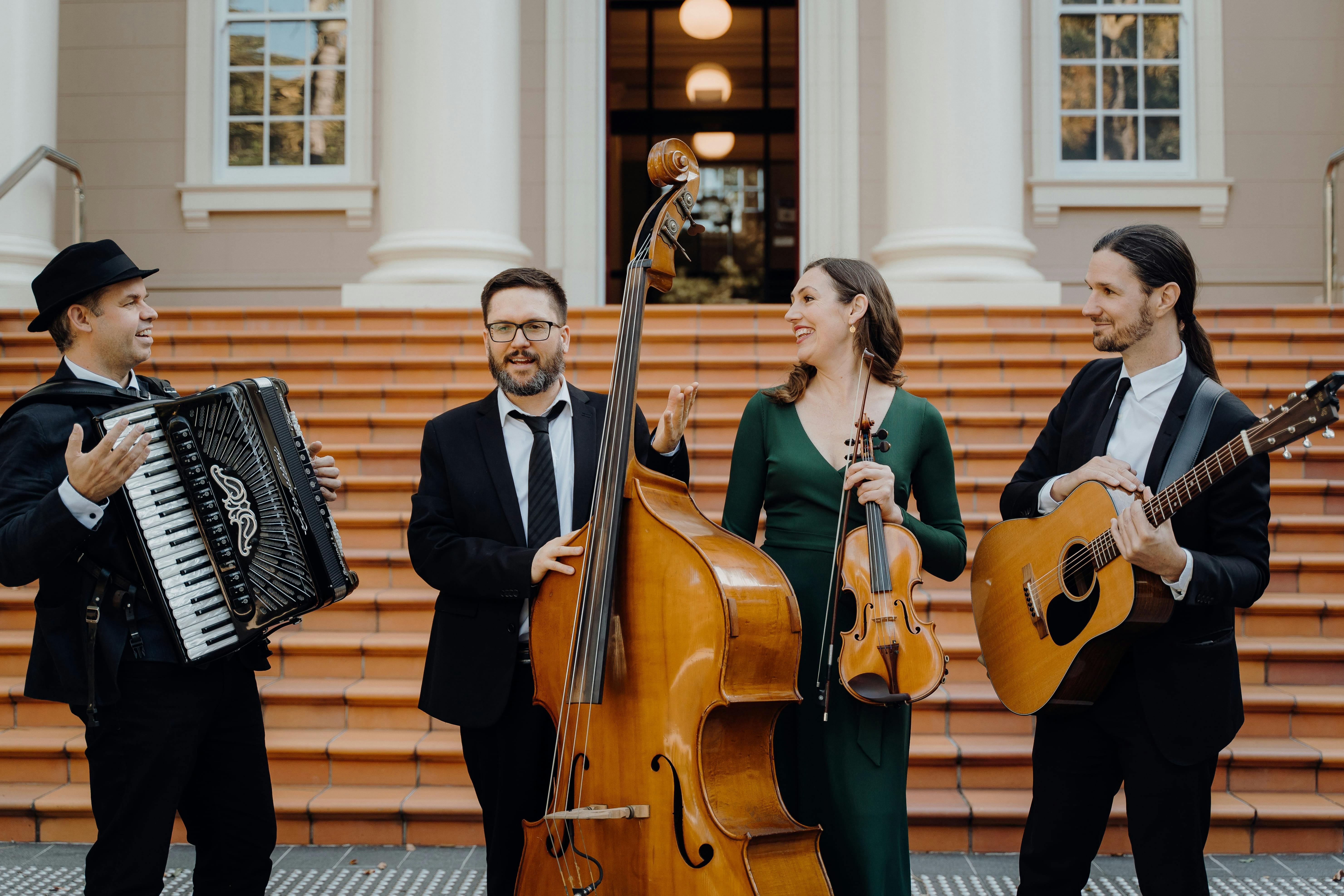 group of musicians with their instruments in front of steps of a building