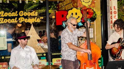 A jazz trio performing outside POP Canberra, entertaining shoppers at community events.