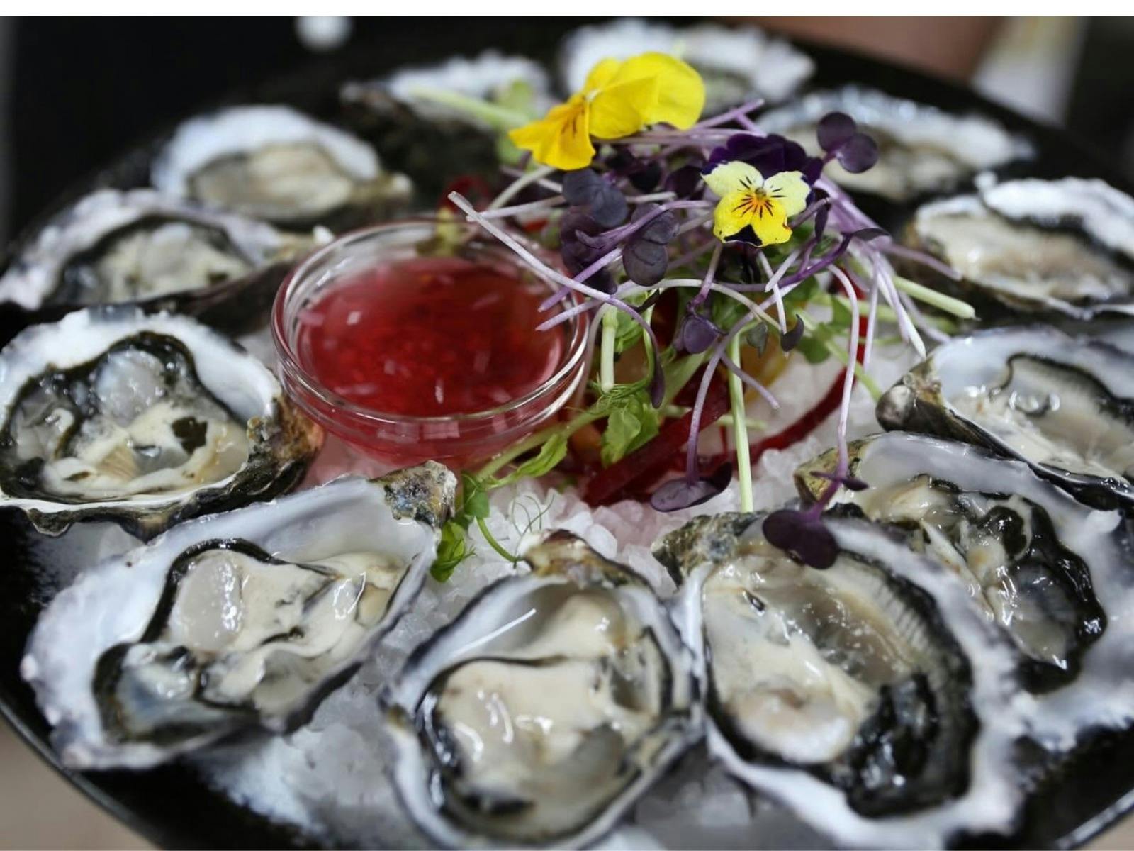 Fresh Tasmanian oysters served on ice with house dressing, microgreens and edible flowers at The Ele