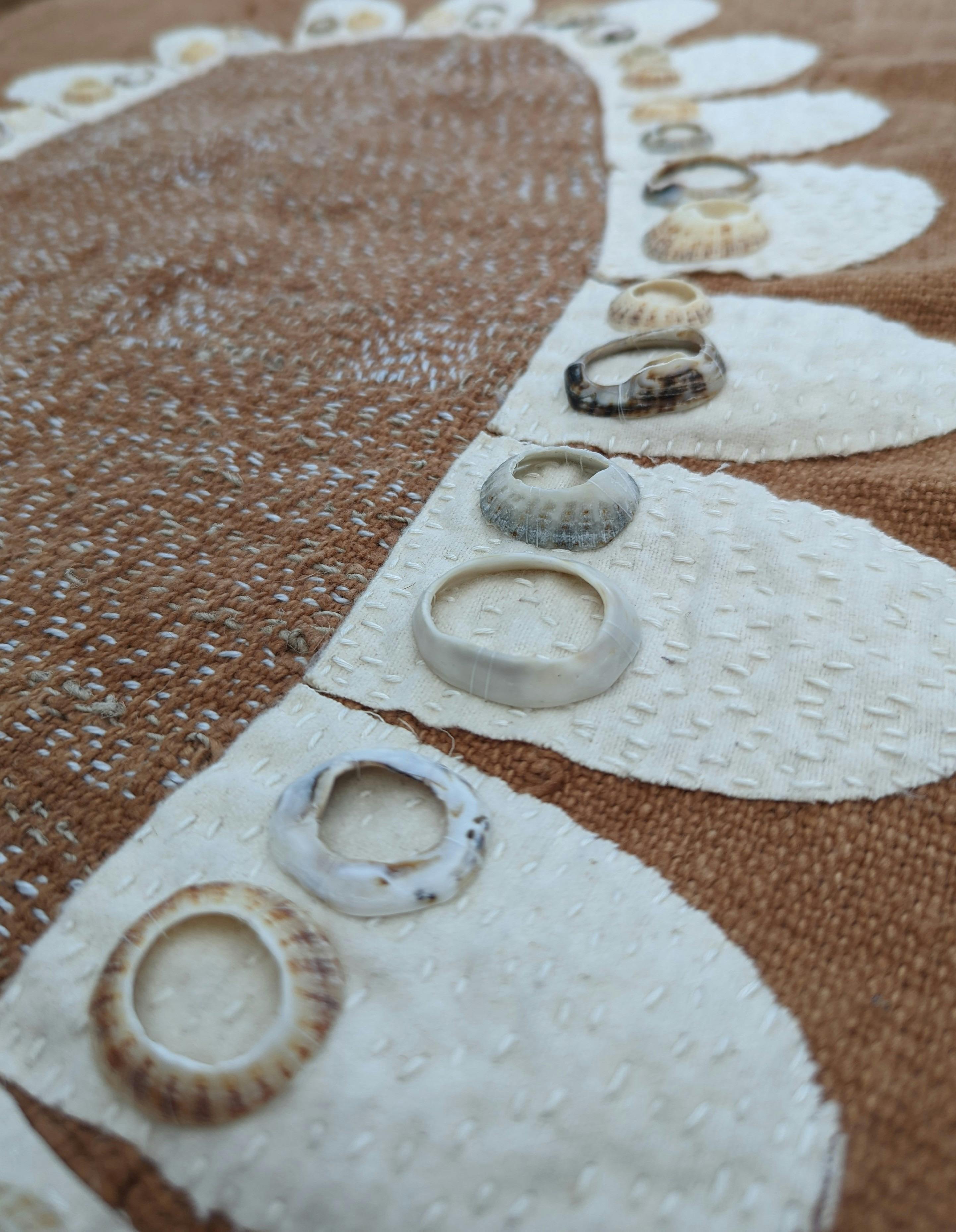 Brown textile with petals in white and natural shells