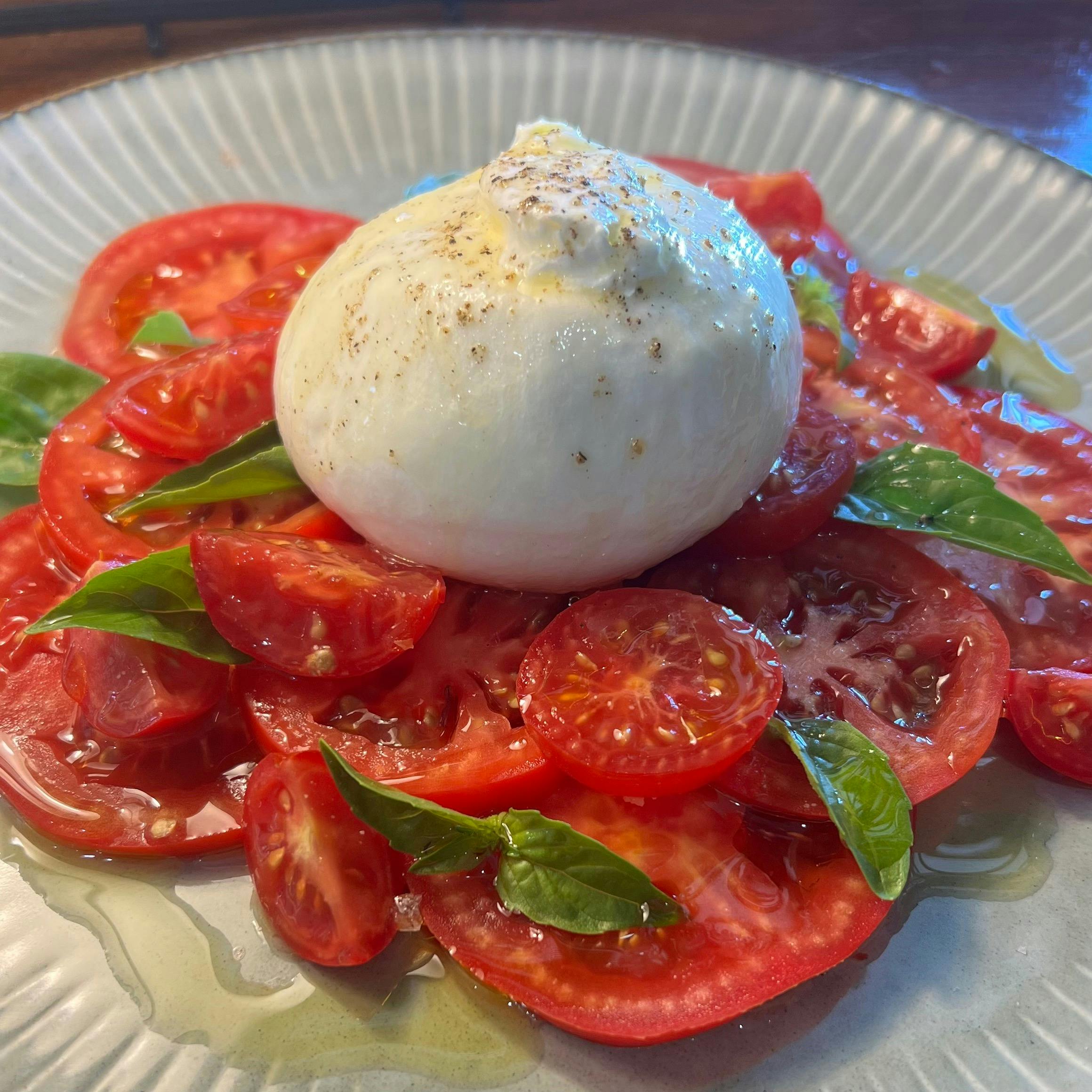 布拉塔奶酪、新鲜的当地番茄和罗勒