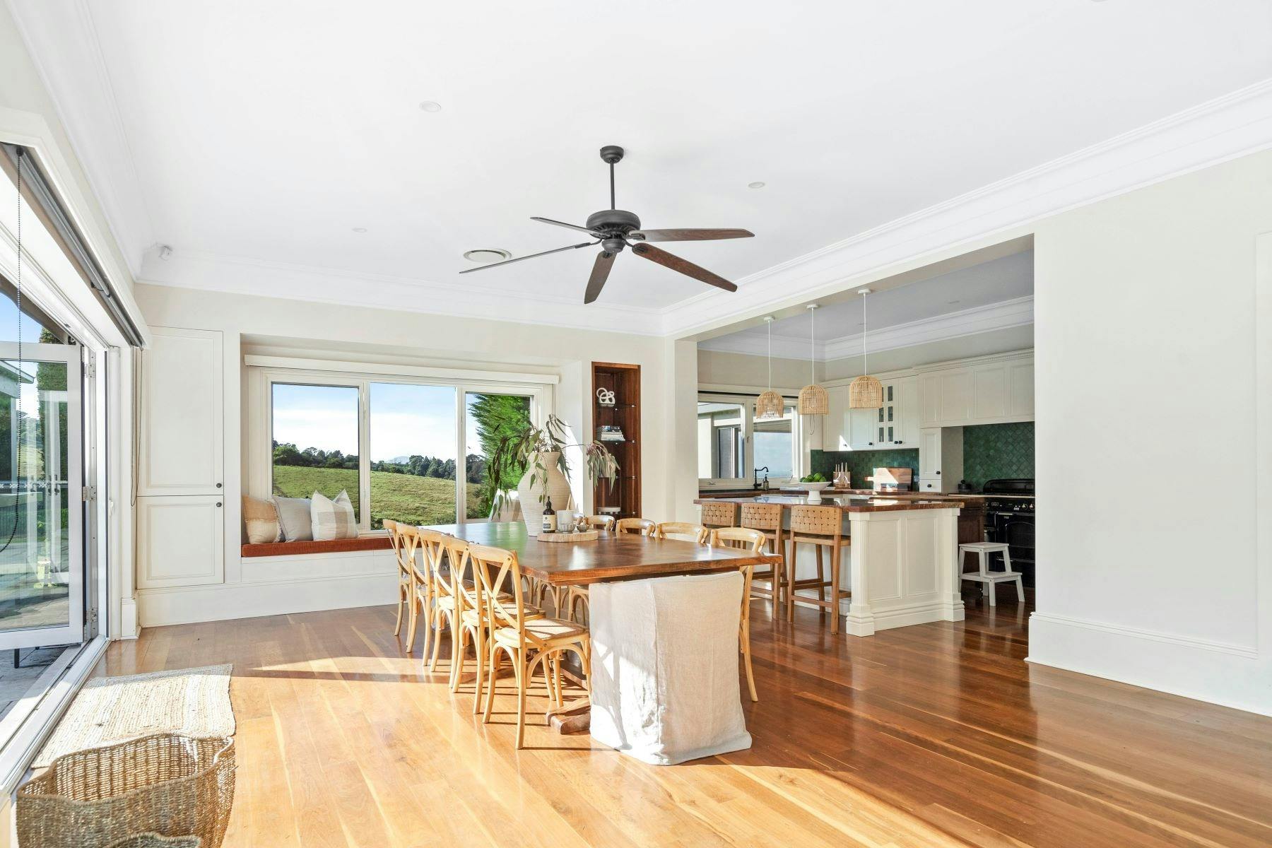 Image of kitchen and dining area. Beautiful mountain views are seen through windows. Timber floors.