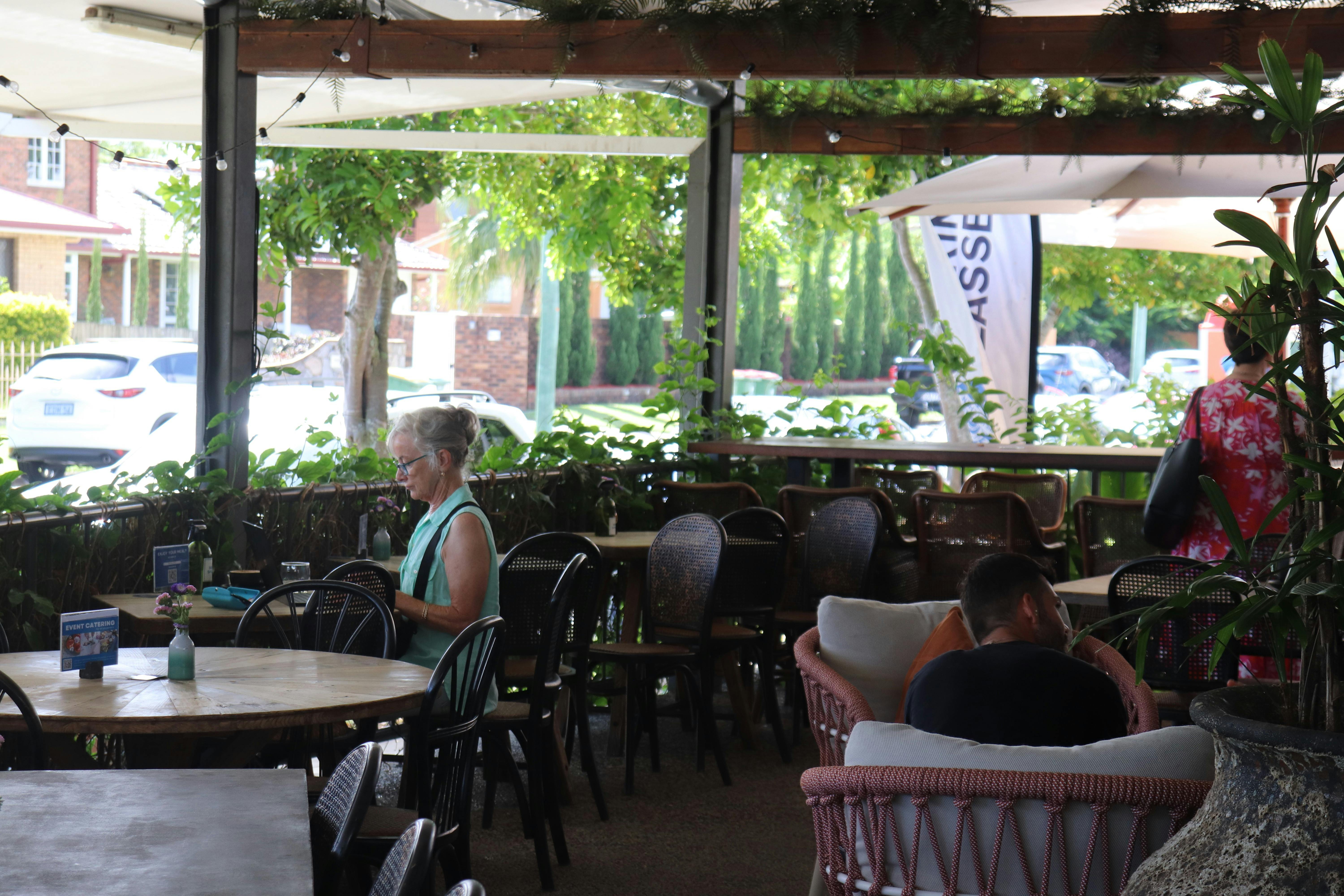 The Pantry's lush, leafy veranda with a refreshing breeze and ocean views.