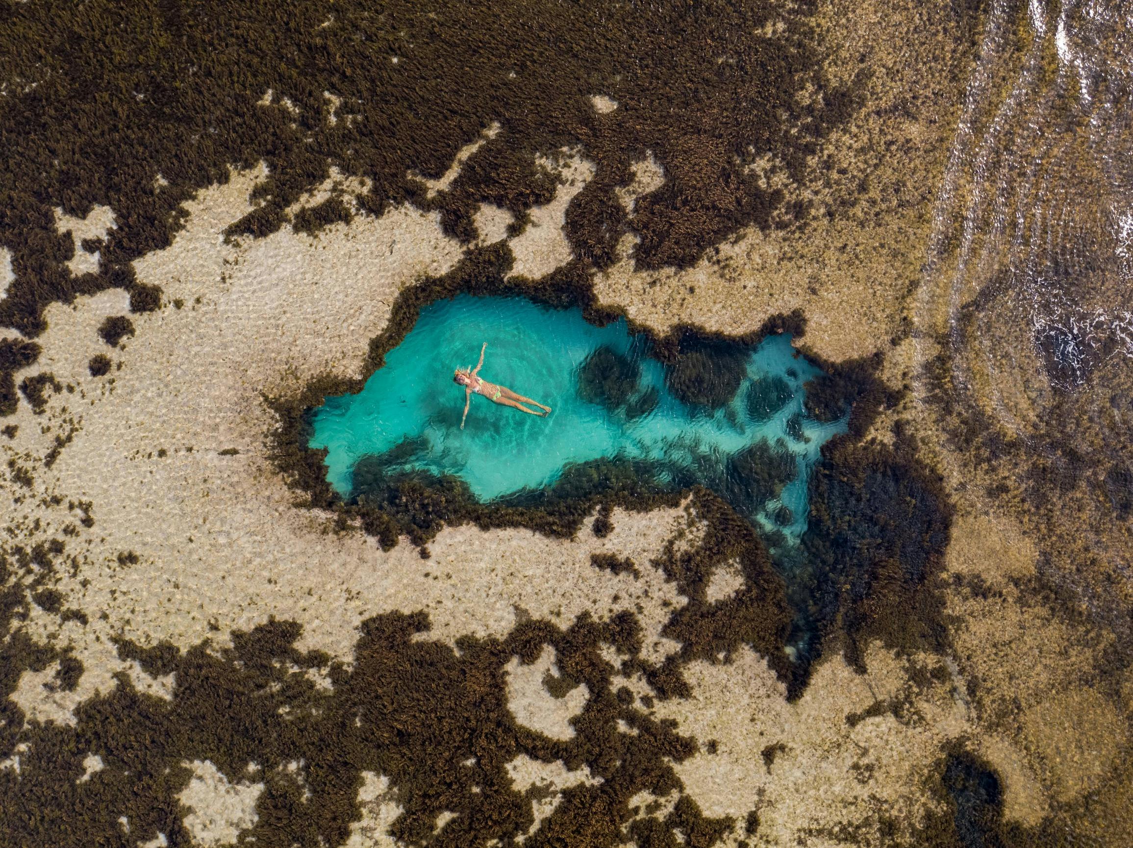 Aerial view of a person swimming in a pool at Little Armstrong Bay on Rottnest Island