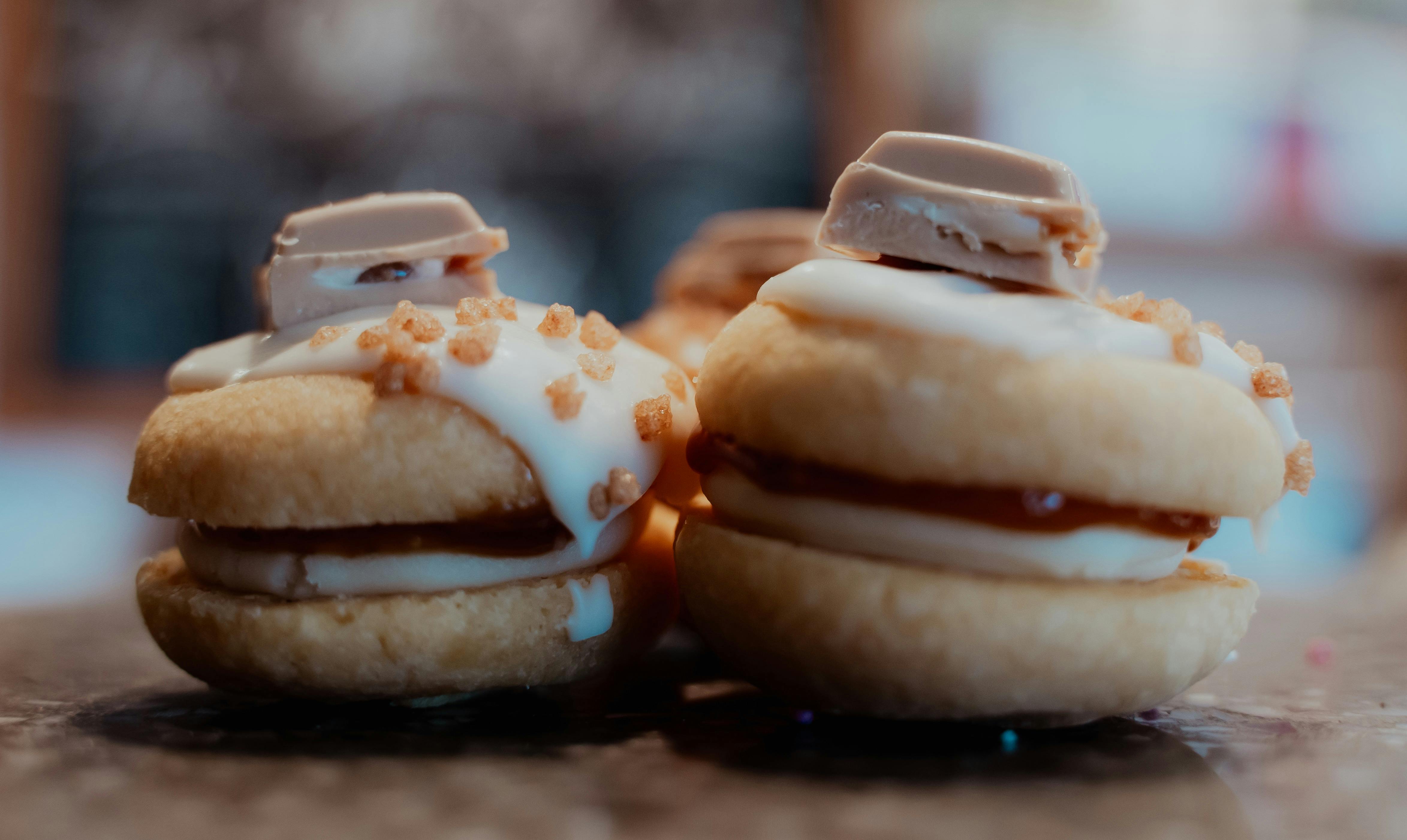 Two melting moment biscuits with icing and sweets on top