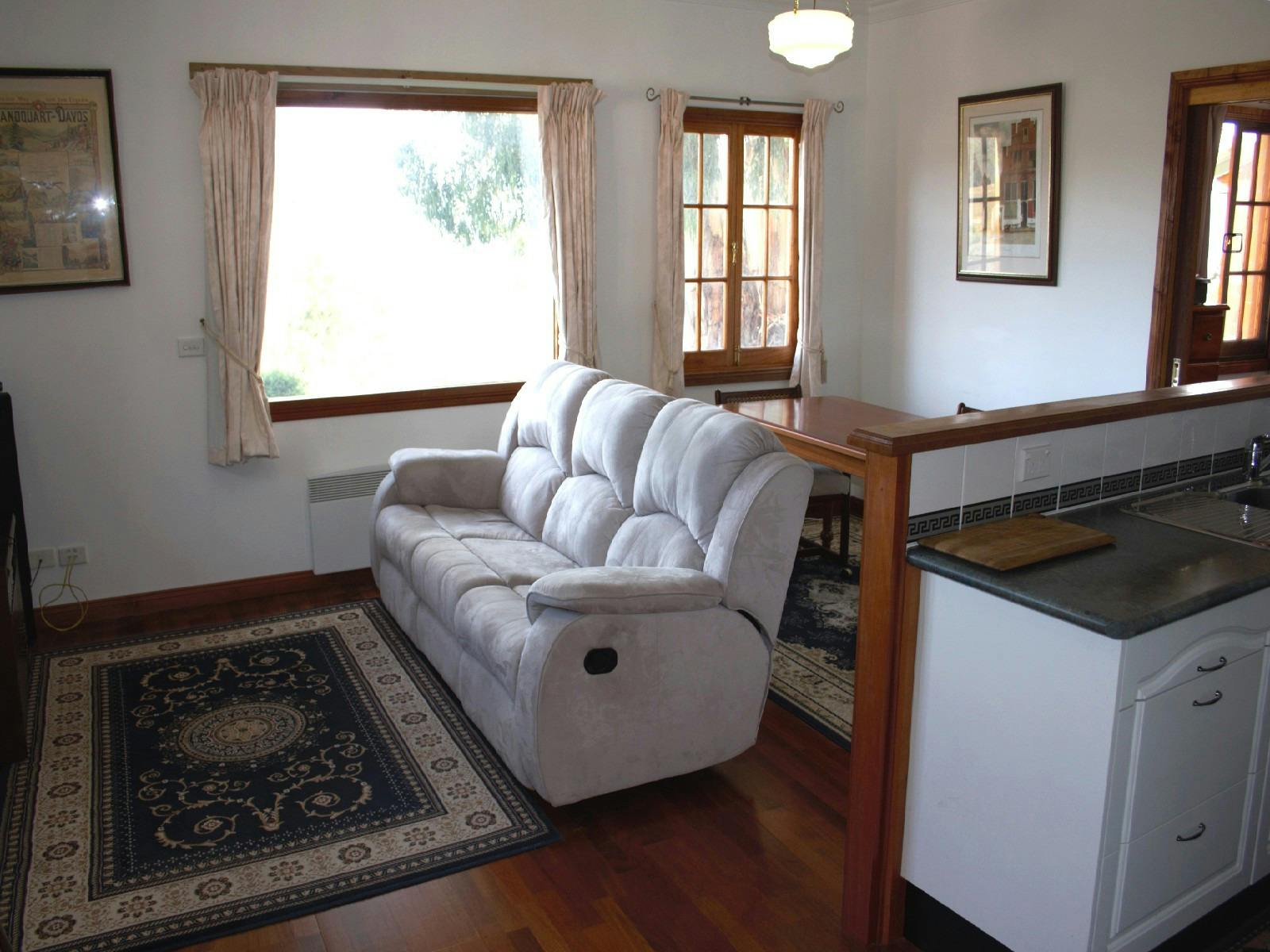 Main living area, couch, galley kitchen, open plan, timber floor, main window,dining table