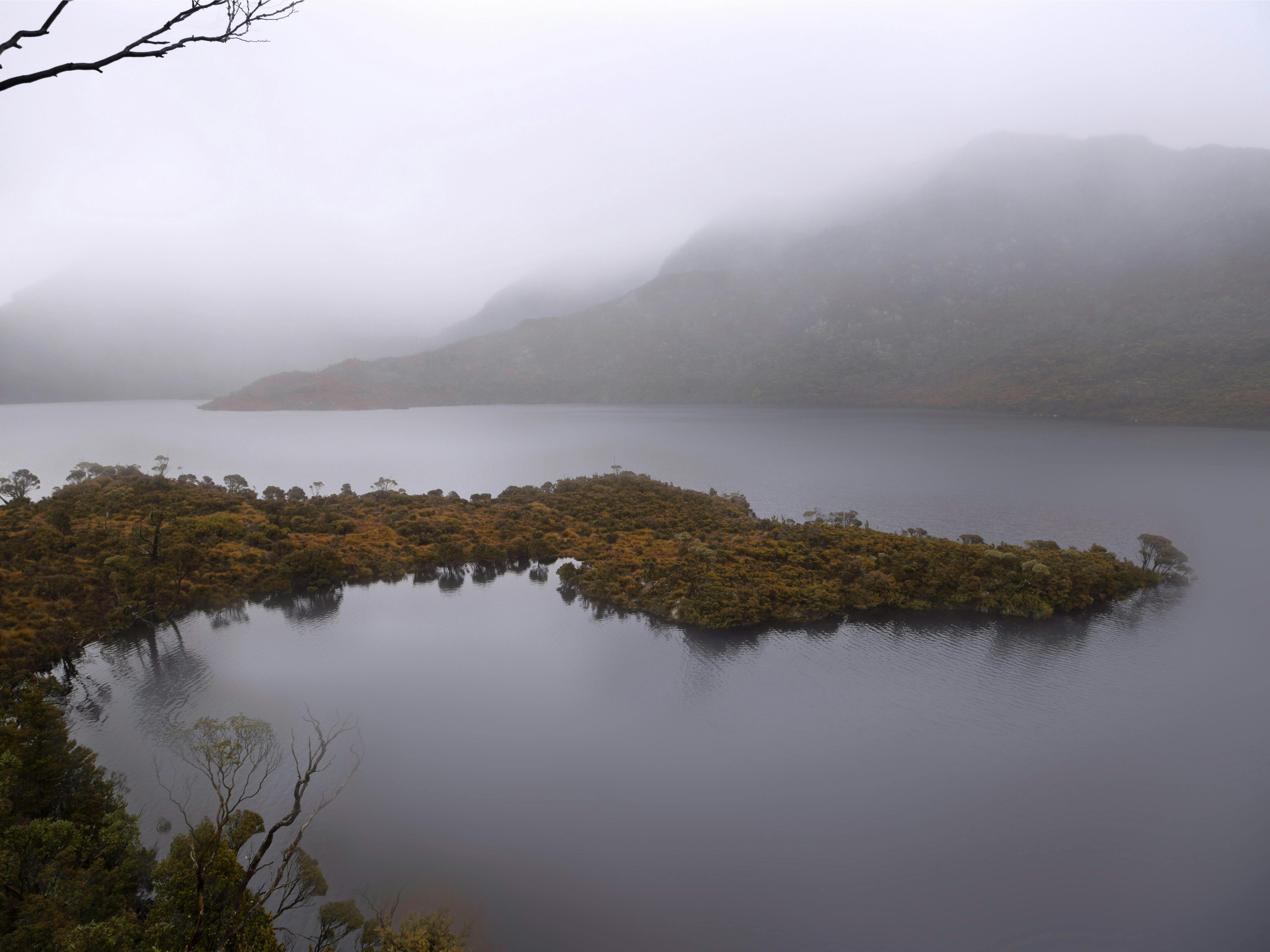 A fog settles and obscures the mountains and Cradle Mountain that surround Dove Lake and peninsula