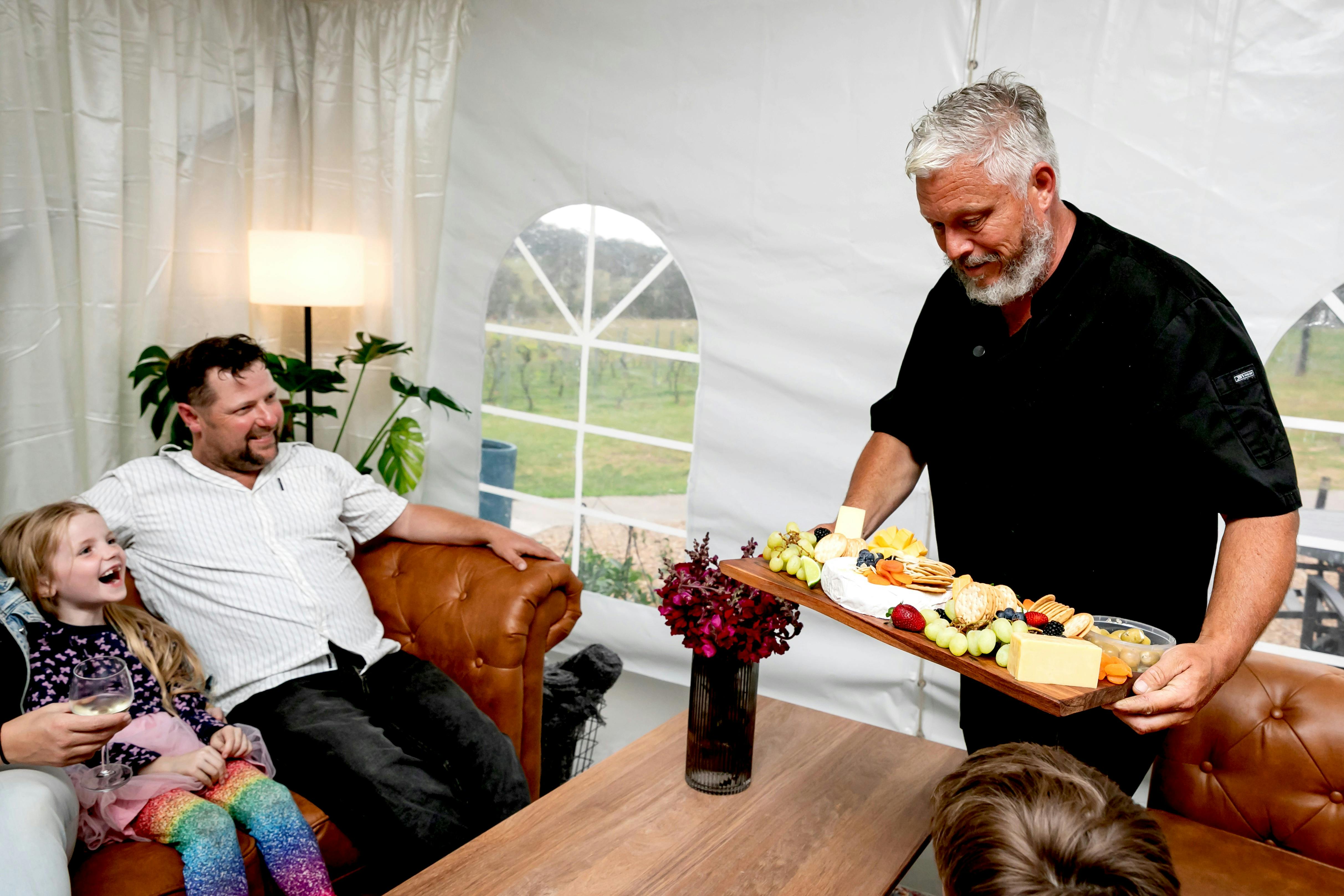 Darryl serving customers in our seating area a cheese platter