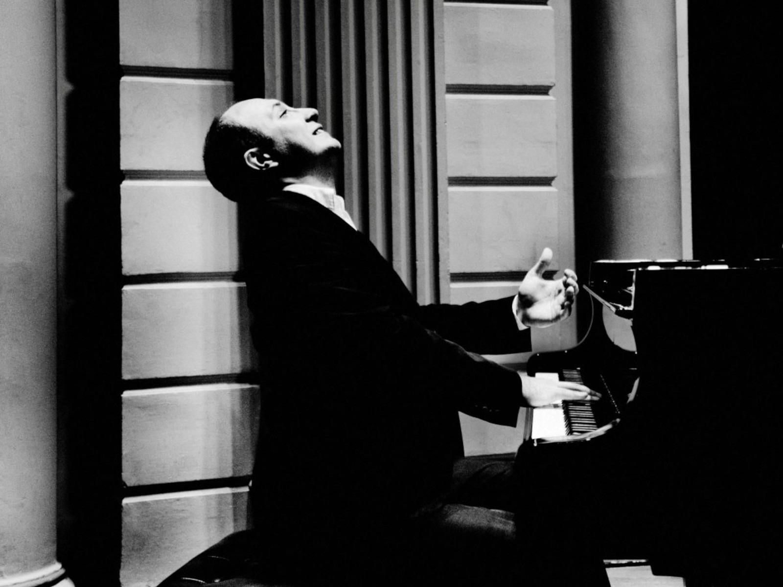 Monochrome image of a solo musician sitting at a piano.