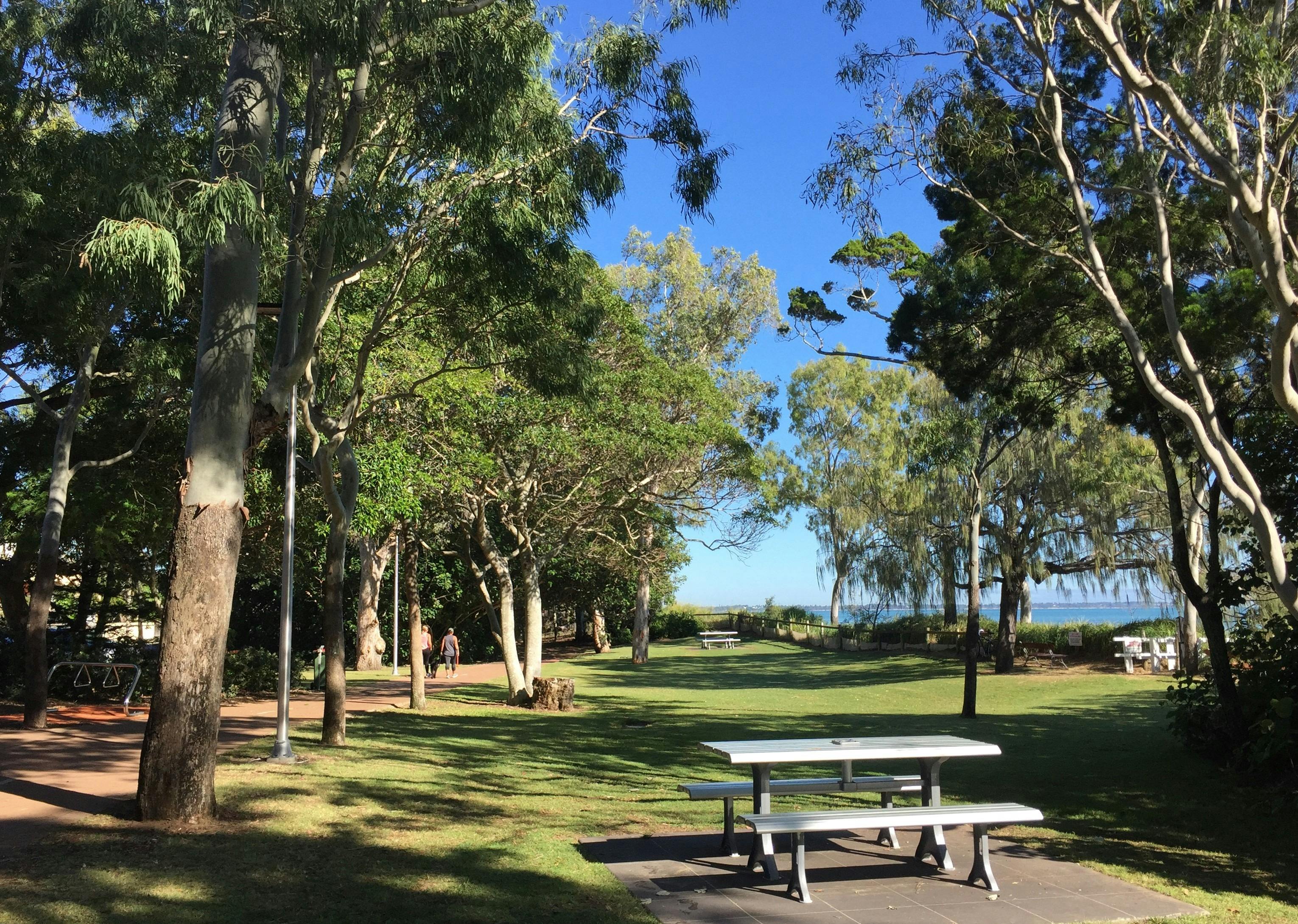photo showing part of Hervey Bay Coastal Pathway near grassed area with picnic table