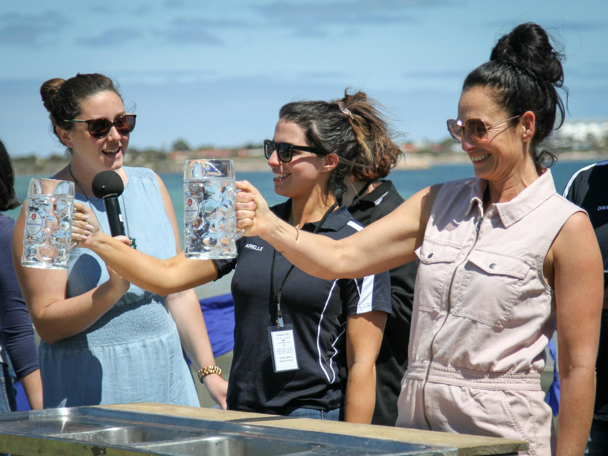 Competitors hold a filled glass stein while being interviewed by ABC Radio's Petria Ladgrove