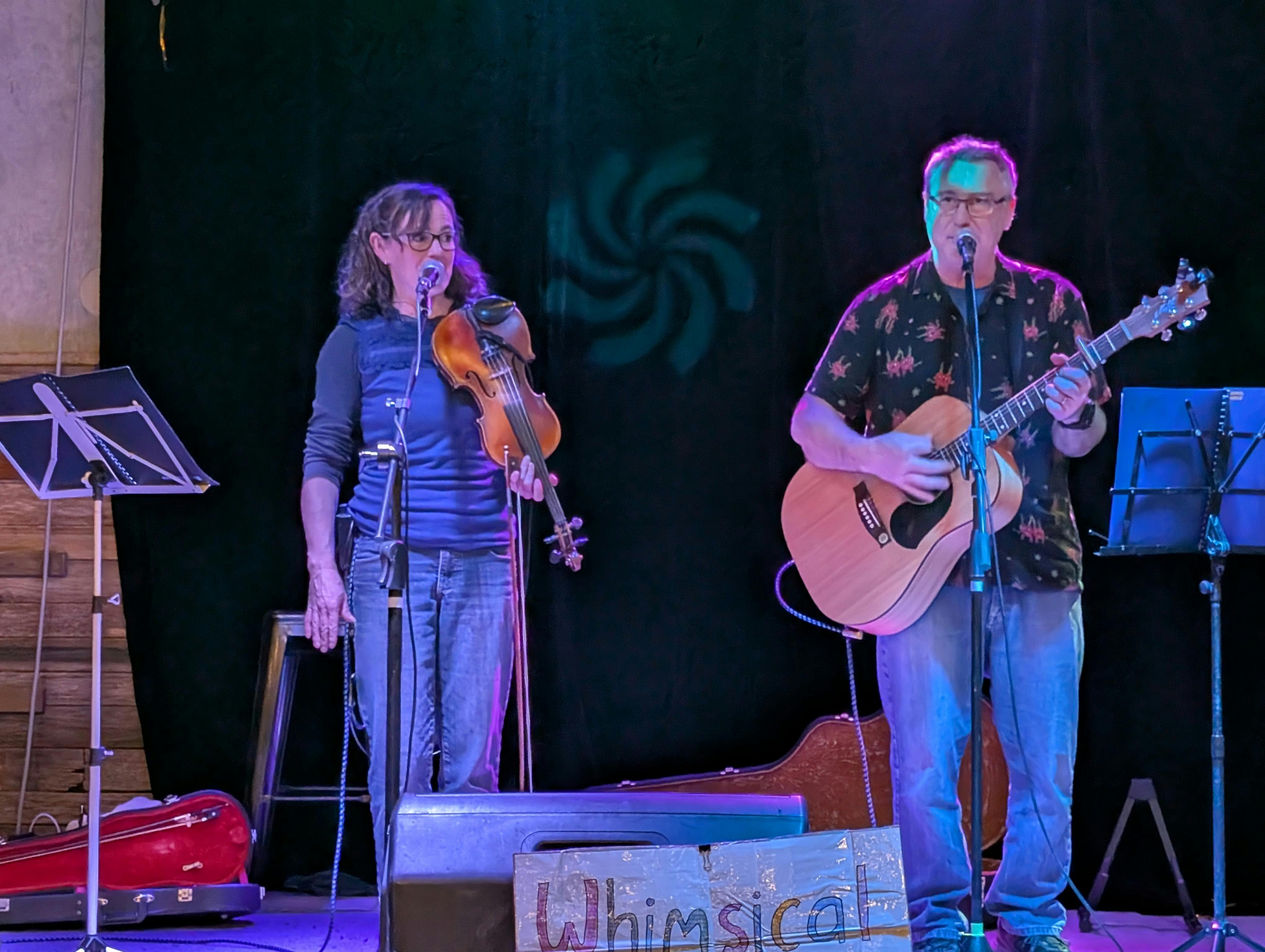 Female violinist and male guitarist on stage