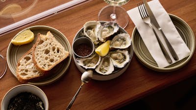 Oysters + Mignonette, served with a side of sourdough and a glass of white wine