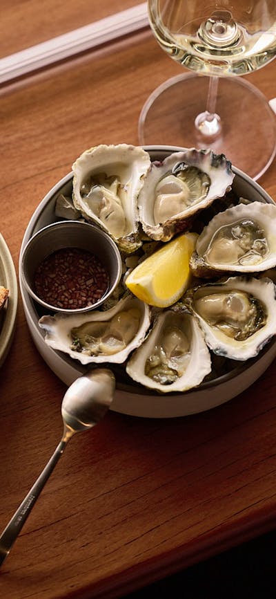Oysters + Mignonette, served with a side of sourdough and a glass of white wine