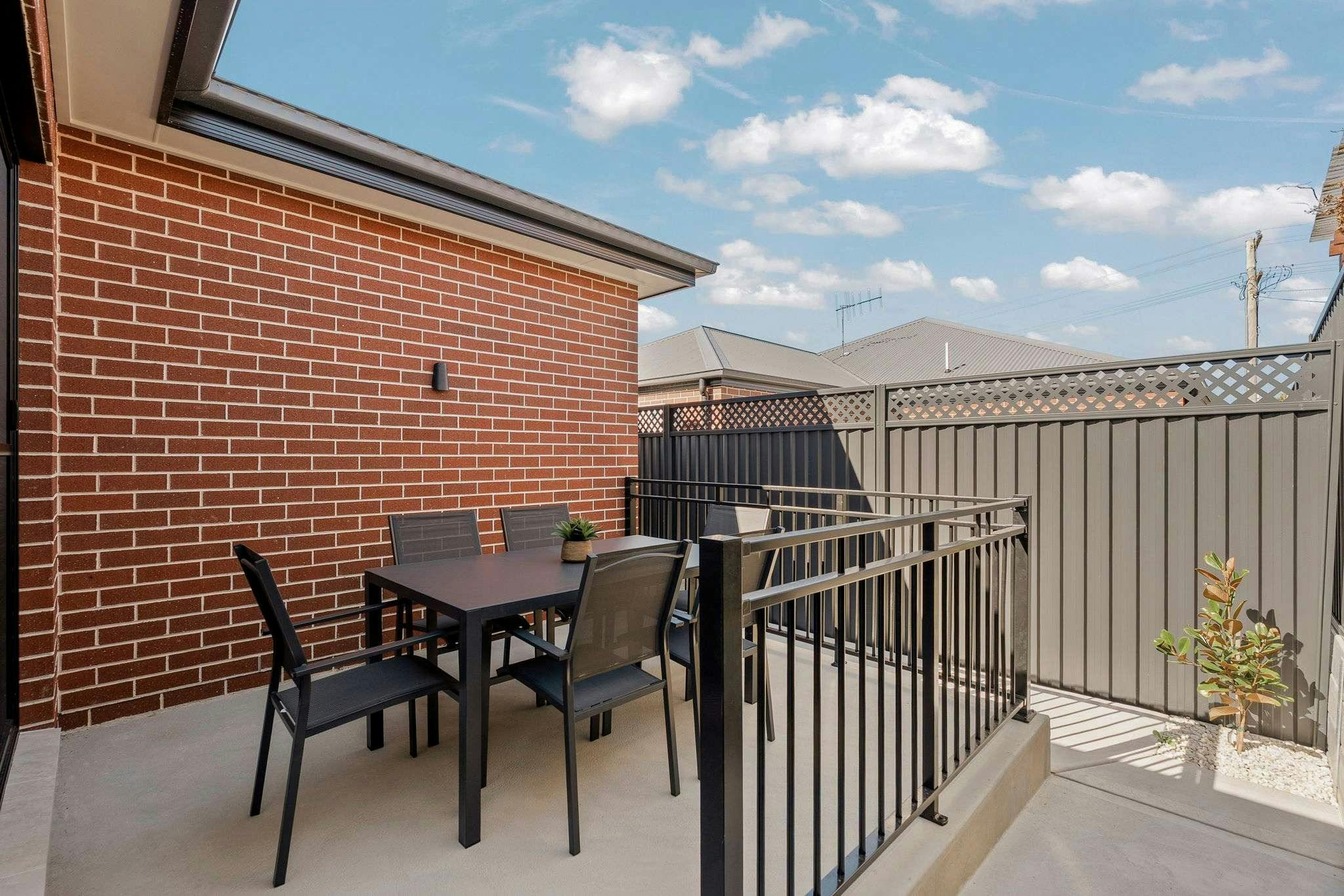 Outdoor dining table with chairs, concrete deck high fence