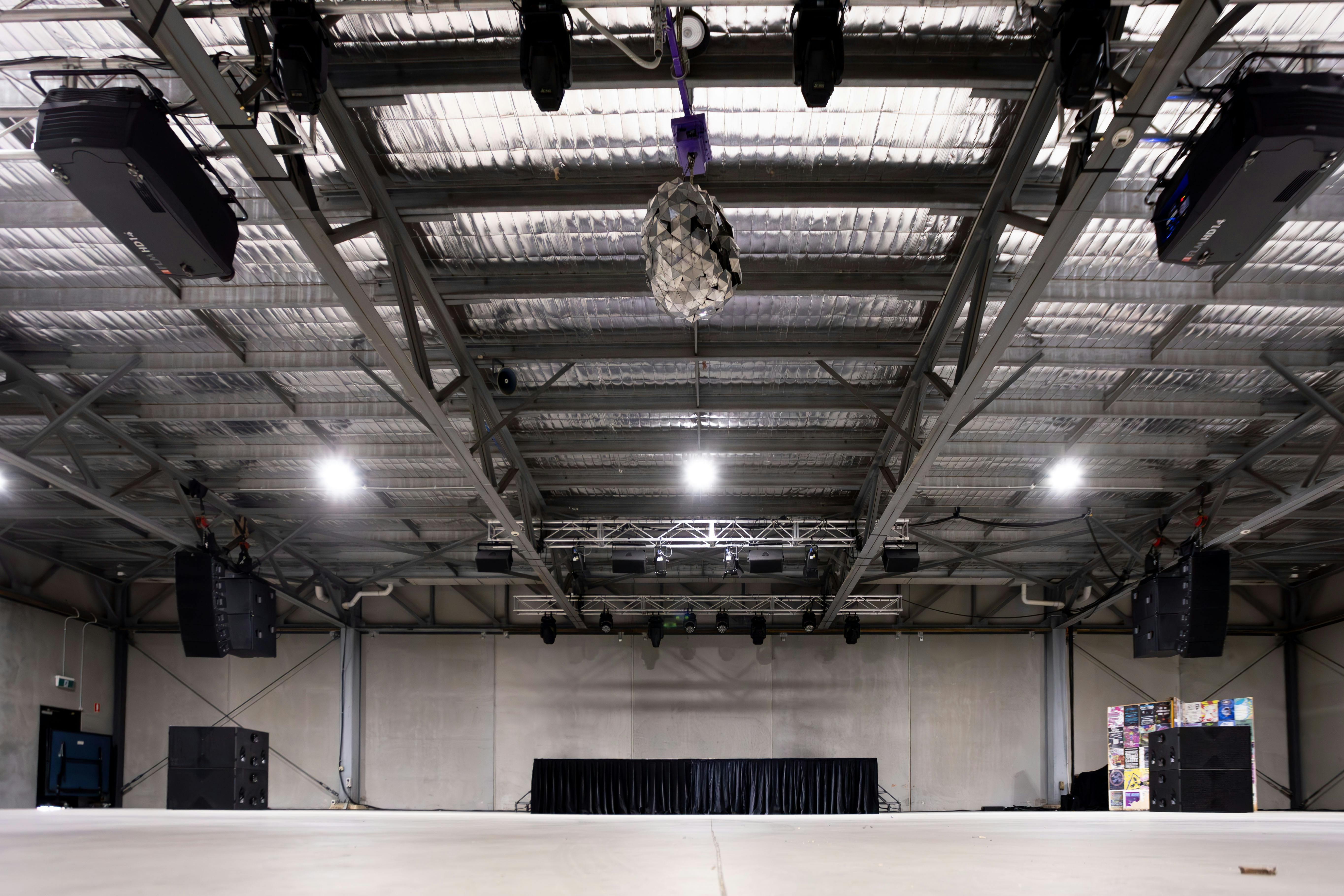 Large indoor space with house lights on and AV system in view