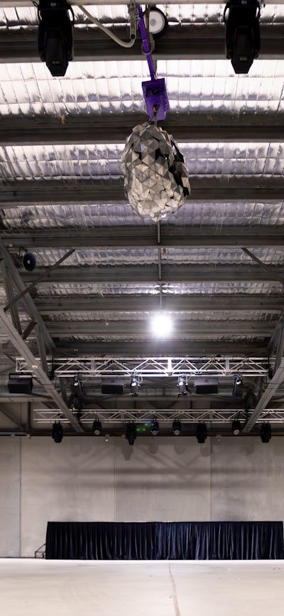 Large indoor space with house lights on and AV system in view