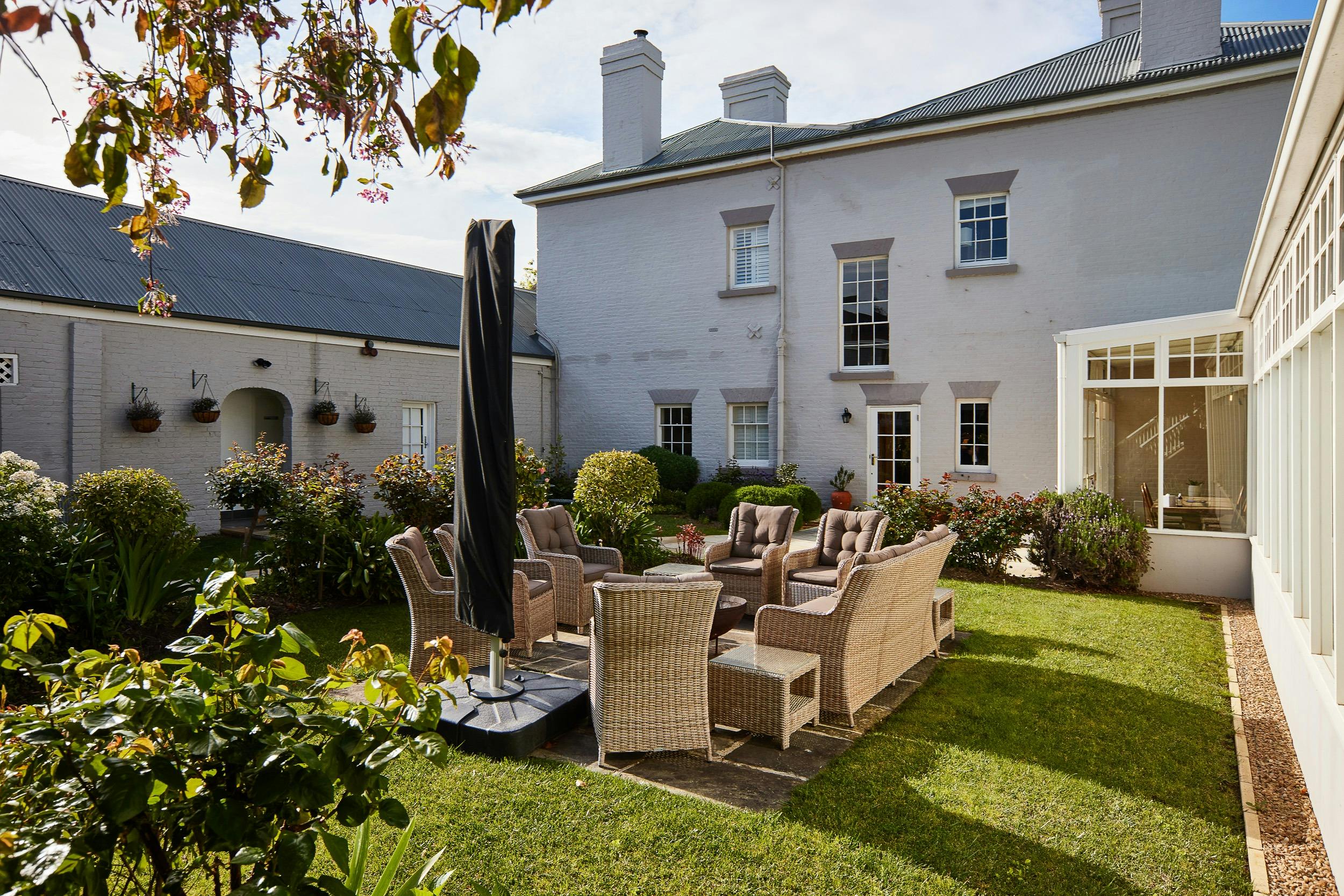Internal courtyard on a sunny day. Outdoor lounge chairs are circling around a fireplace.