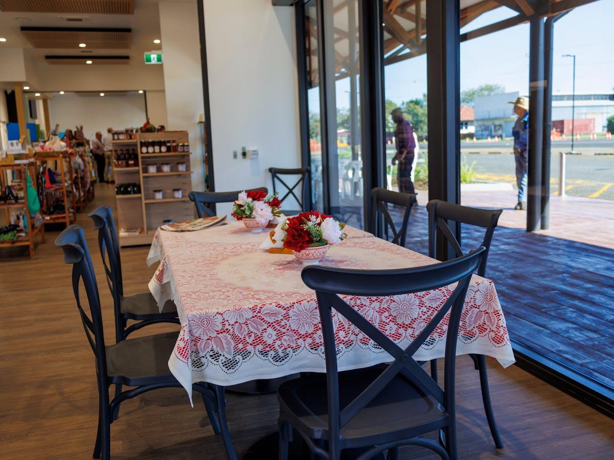 A table with red and white tablecloth and black chairs