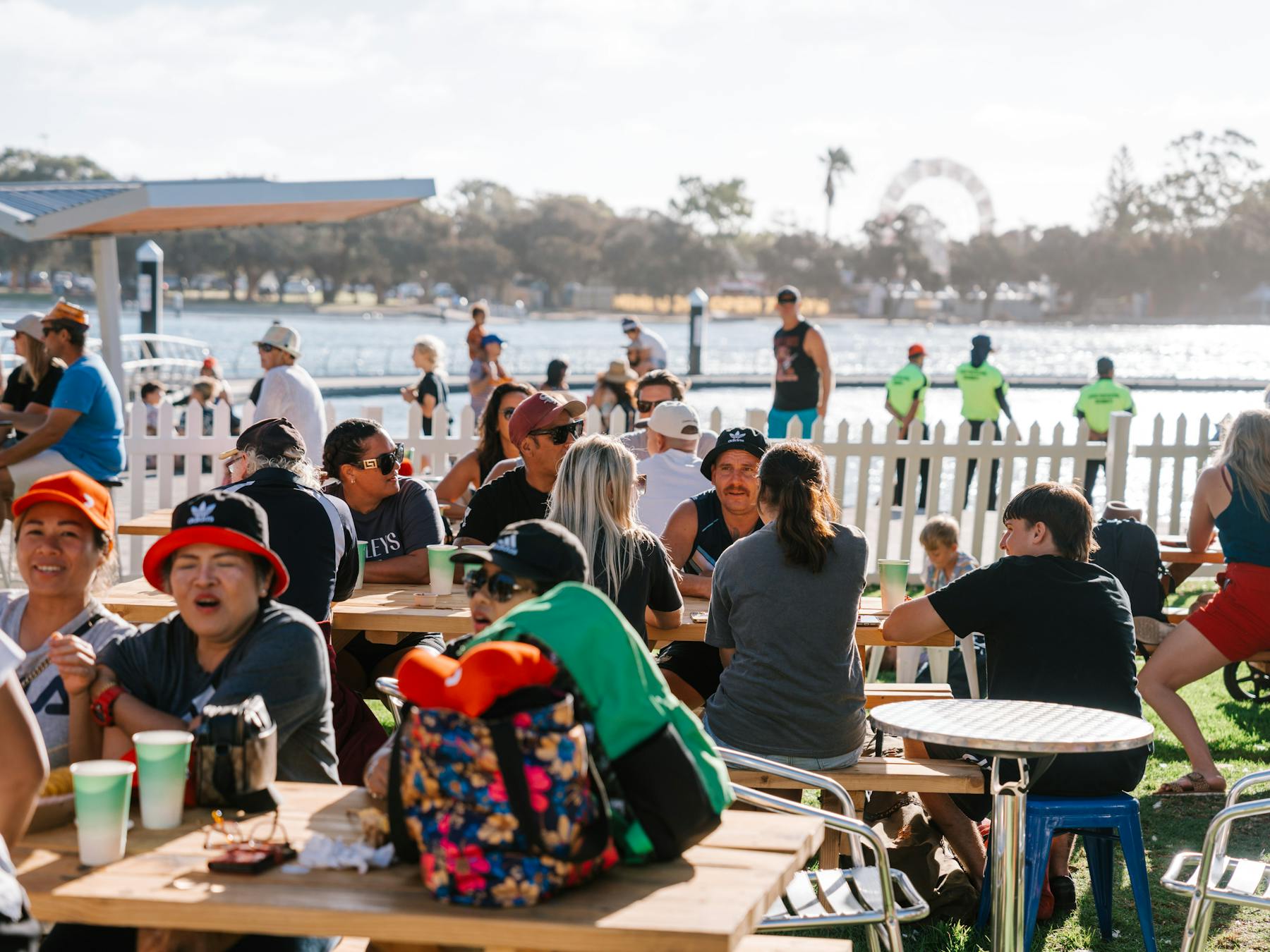 Crowd sitting down enjoying food with water in the background