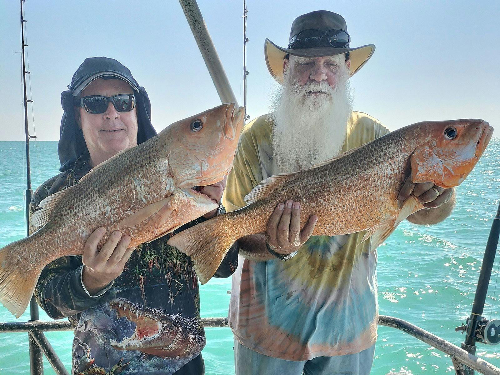 A man holding a fish on a Darwin Red Devil Charter.