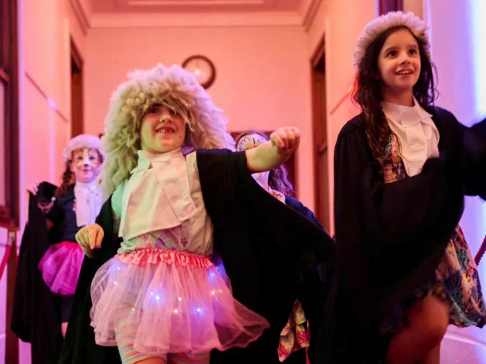 Kids dressed up in costumes walking down a hallway at Old Parliament House